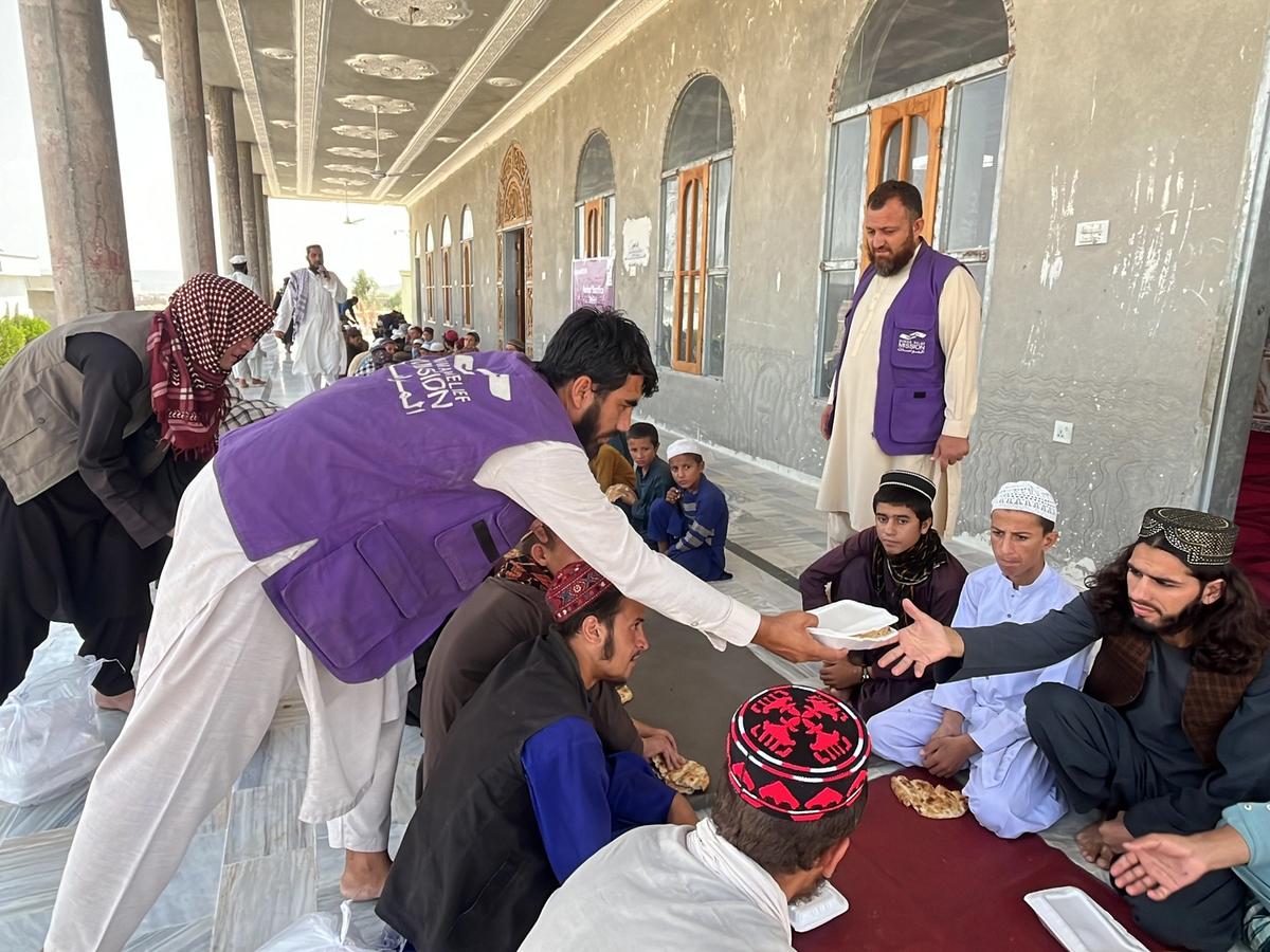 HRM Charity Aid Worker Giving Hot Meals to a Community | Human Relief Mission