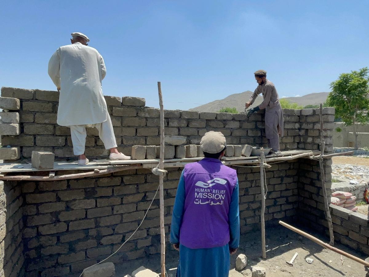 HRM Charity Aid worker helping to build a home with builders in Afghanistan | Human Relief Mission