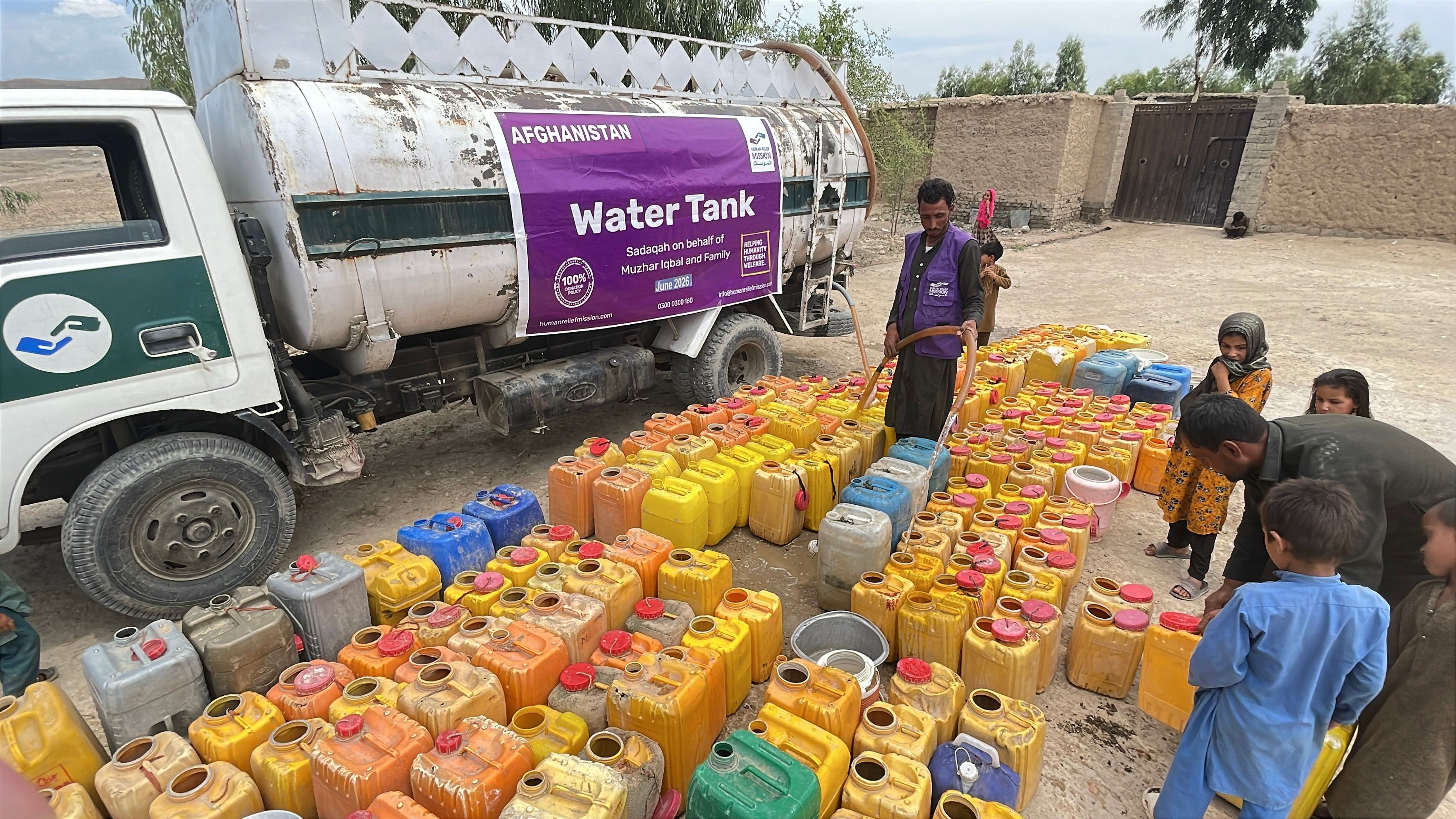 Buckets being filled up from a water tanker by HRM Aid Worker in Afghanistan | Human Relief Mission