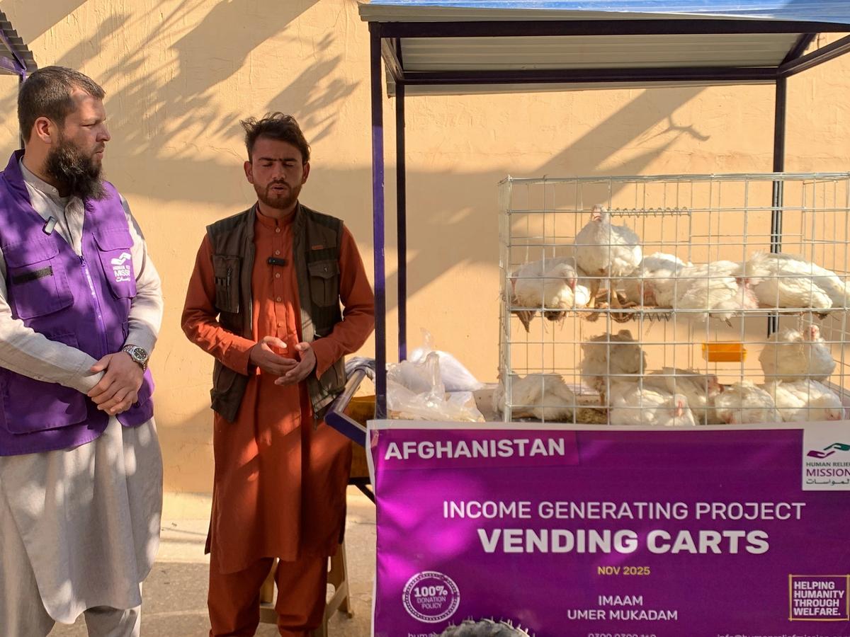 Afghan man with his chicken cart (IGP) with Human Relief Mission aid worker