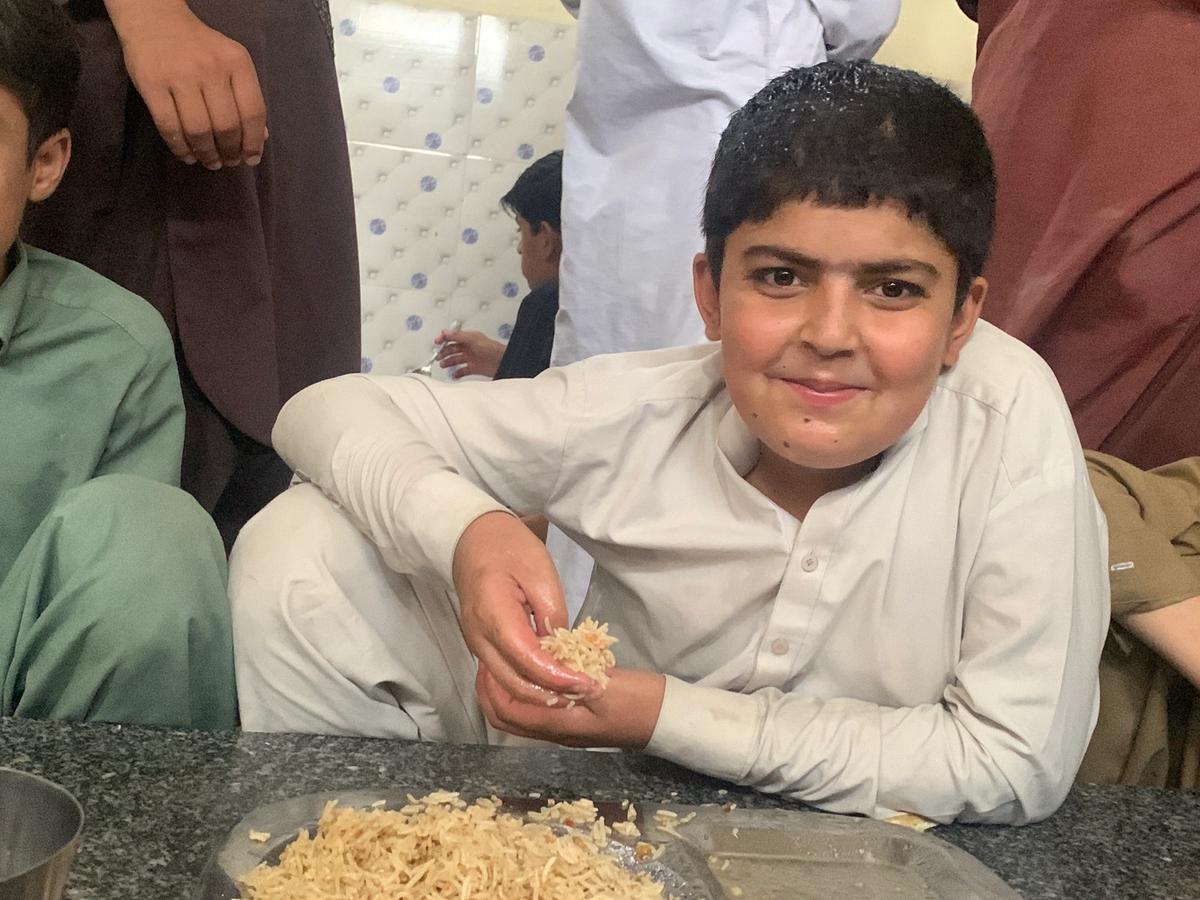 A child eating a fresh hot meal in Afghanistan | Human Relief Mission