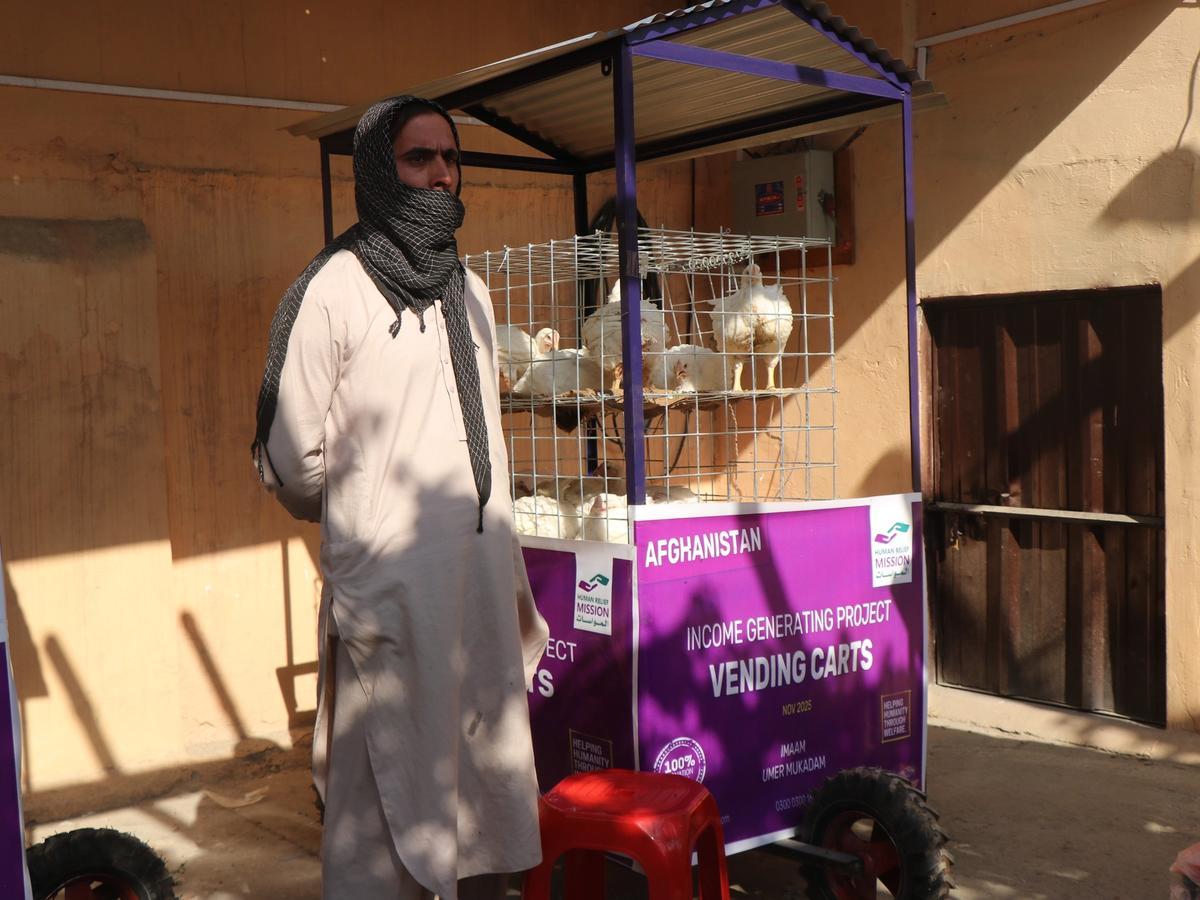 Afghan man with his chicken cart (IGP) with Human Relief Mission aid worker