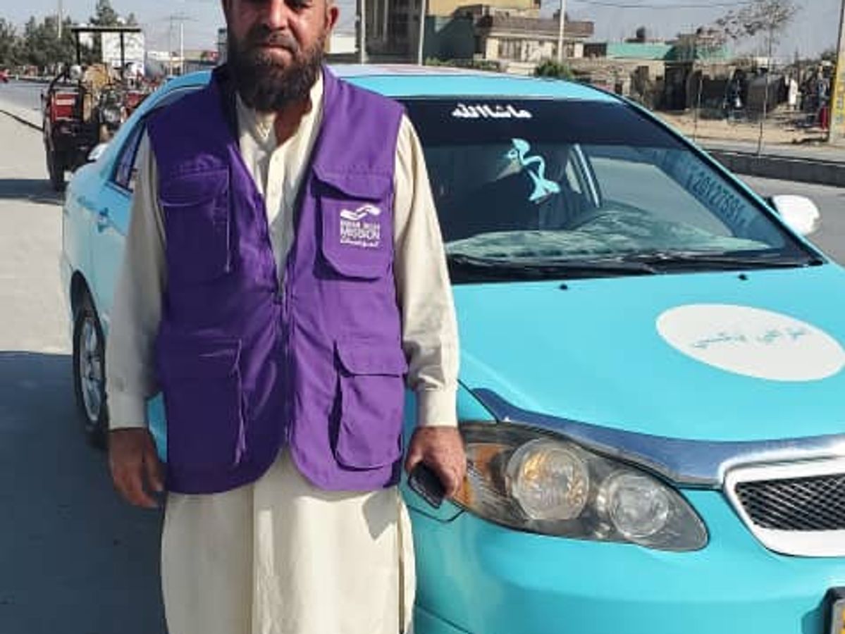 HRM Aid worker standing next to Taxi | Human Relief Mission