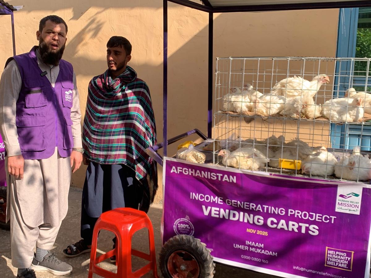 Afghan man with his chicken cart (IGP) with Human Relief Mission aid worker