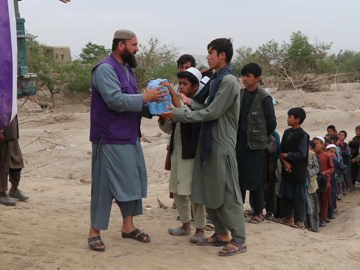 Afghanistan families receiving a case of water bottles | Human Relief Mission