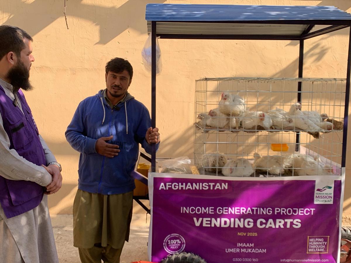 Afghan man with his chicken cart (IGP) with Human Relief Mission aid worker