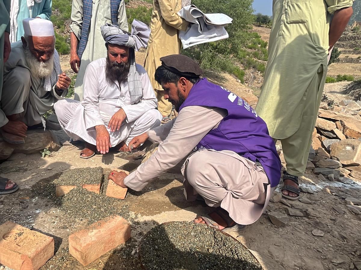 Locals in Afghanistan and HRM Charity Aid Worker laying the first dew bricks for a masjid | Human Relief Mission
