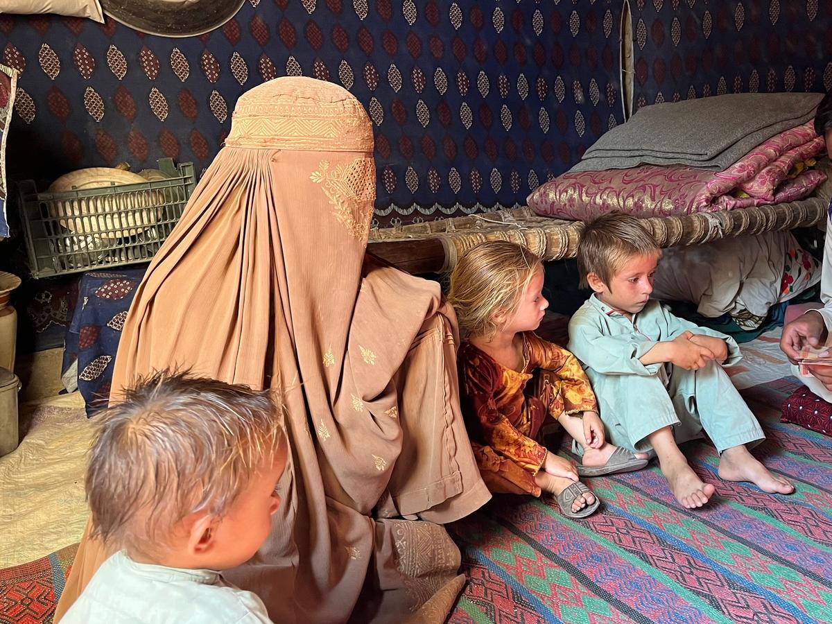 Widow with her family and HRM Charity Aid Worker giving cash | Human Relief Mission