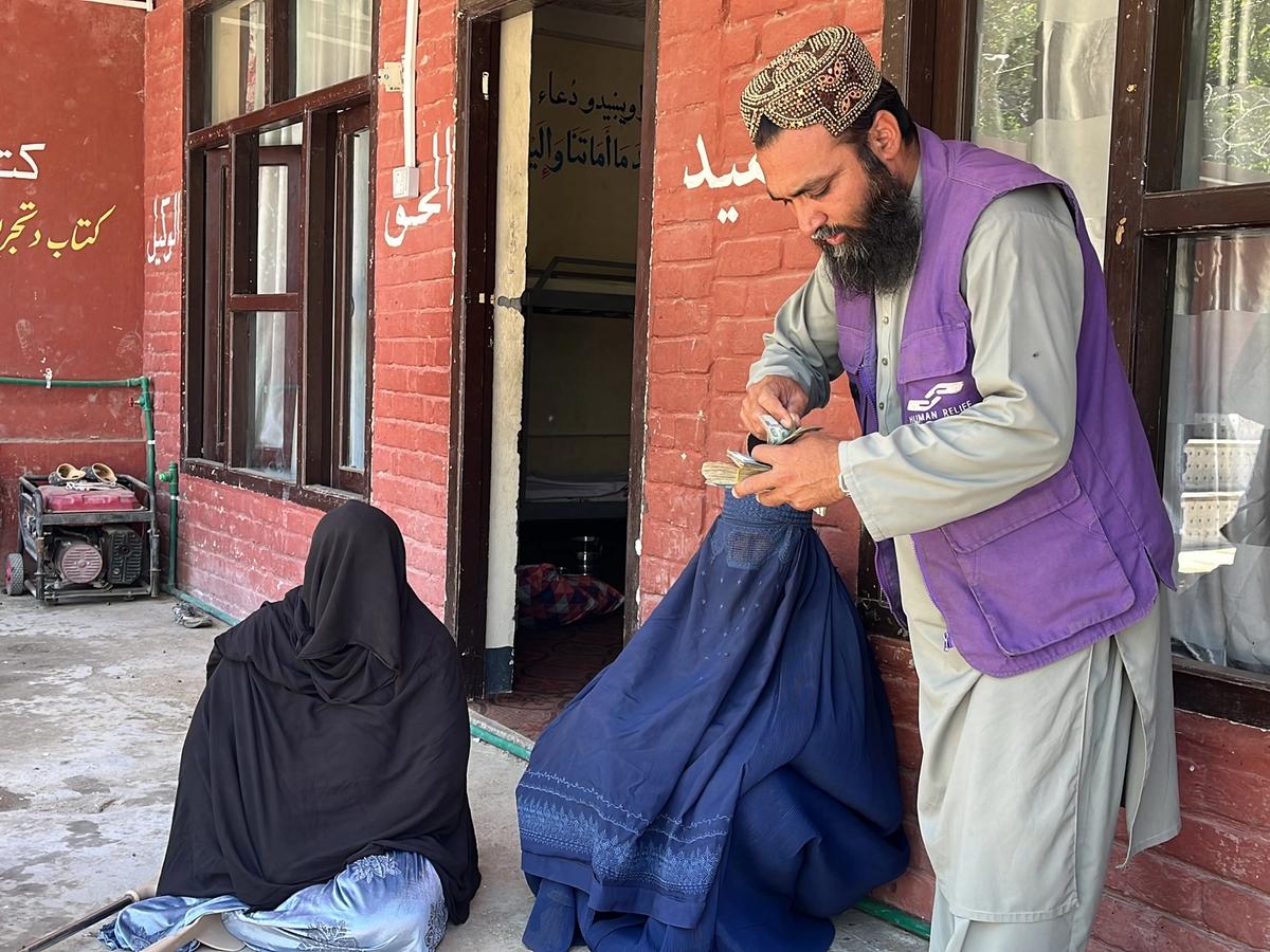 HRM Charity Aid Worker giving cash to Widows | Human Relief Mission