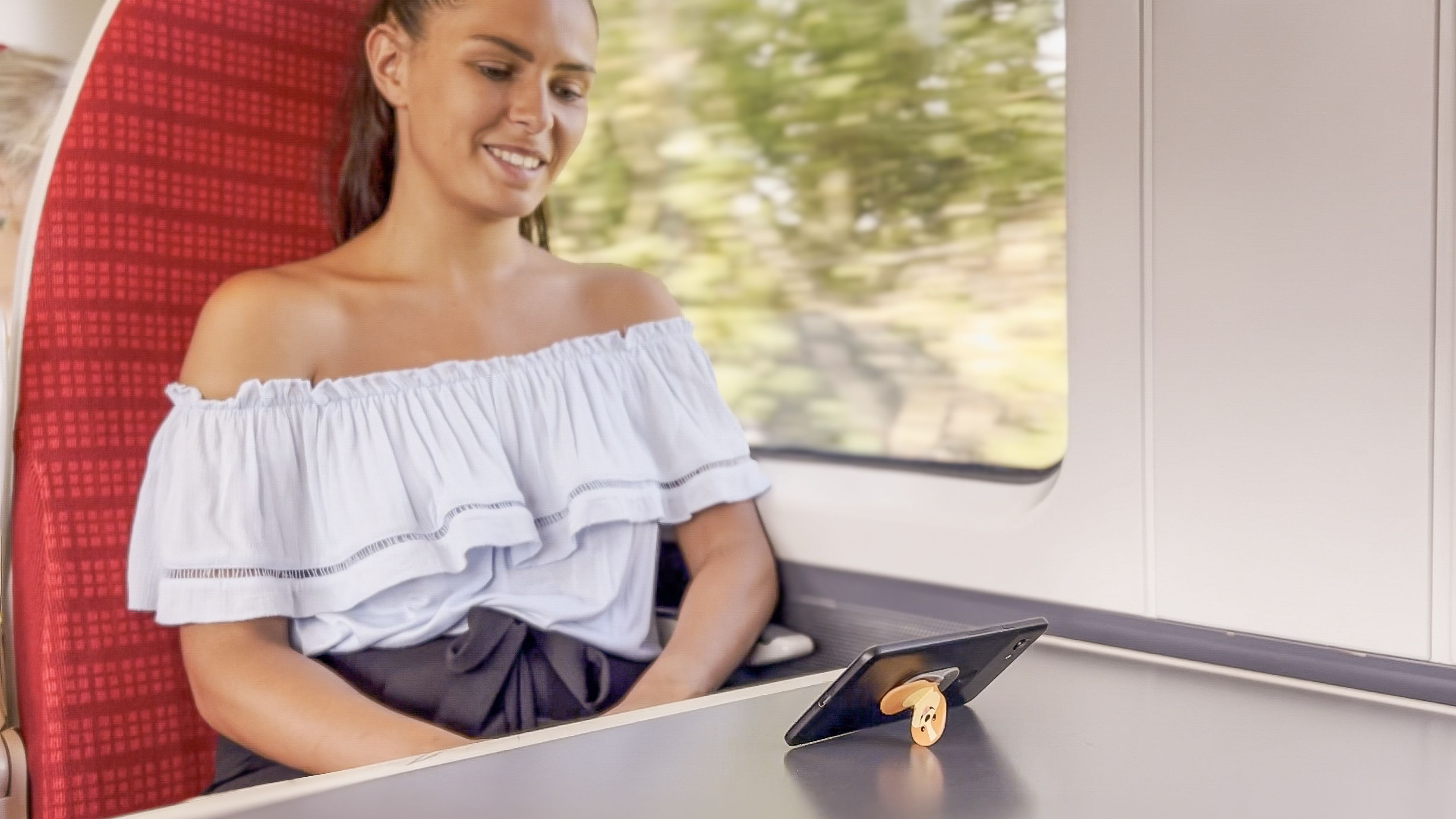 A woman on a train enjoying her phone holder