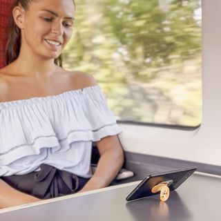 A woman on a train enjoying her phone holder