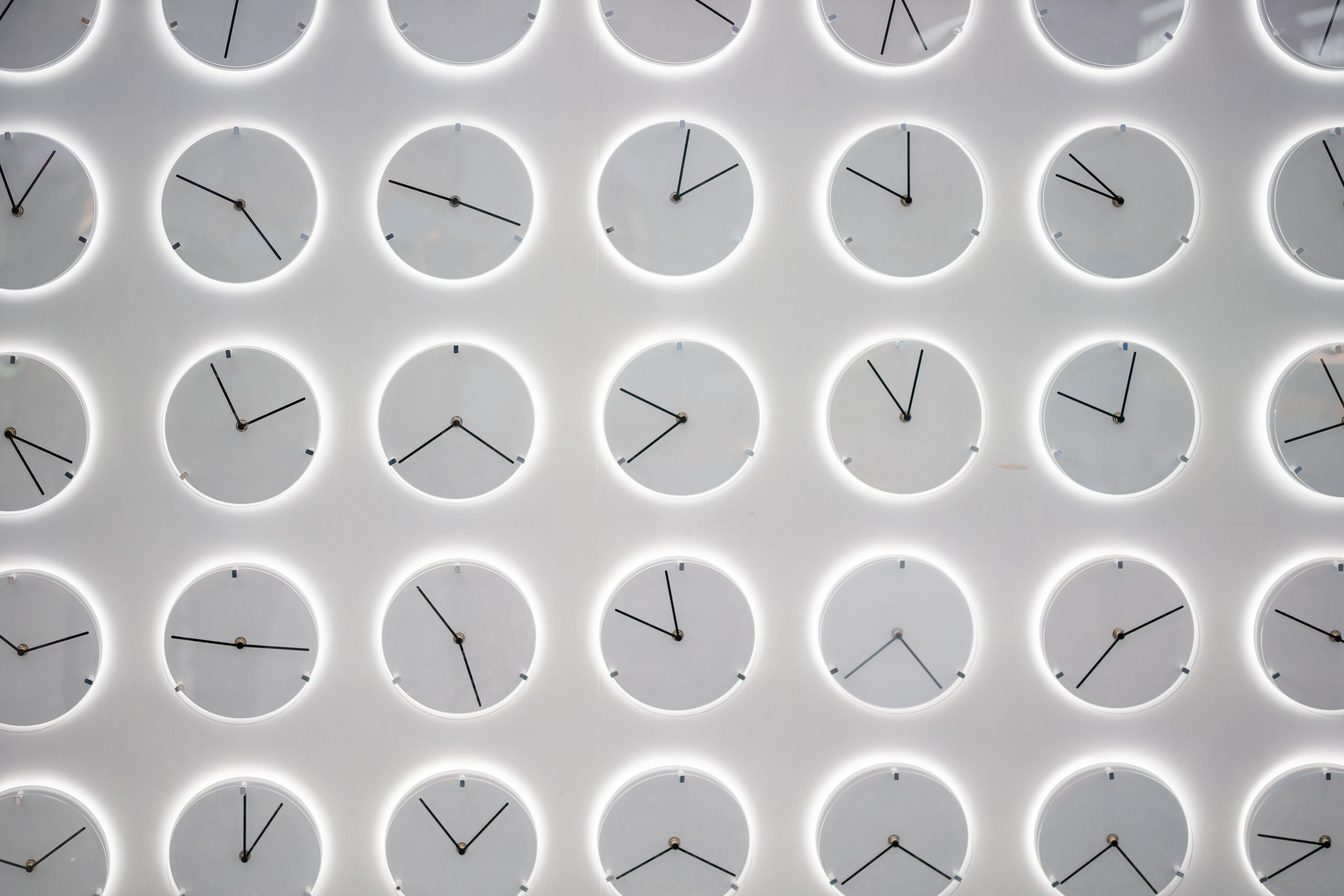 5 rows of identical clocks with different times, each casting a white background as a shadow