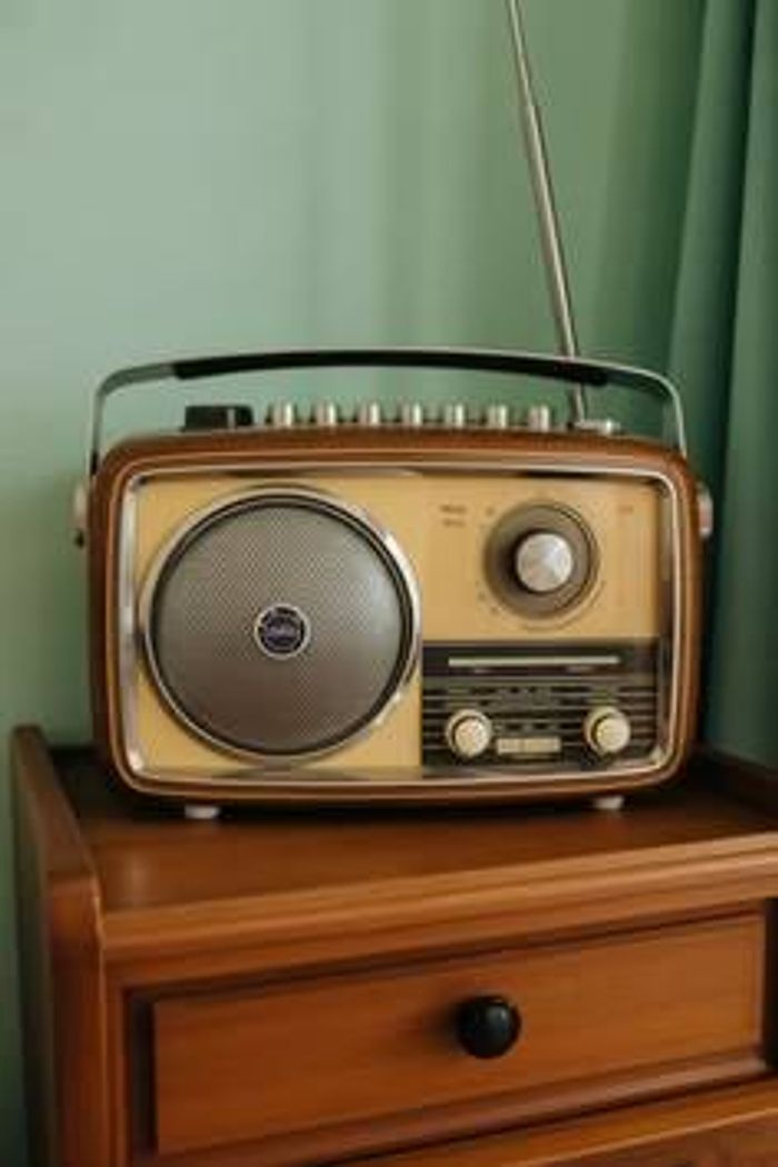 Vintage radio set on a wooden bedside cabinet at home