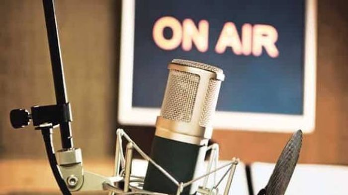 Studio microphone in front of a lit On Air sign