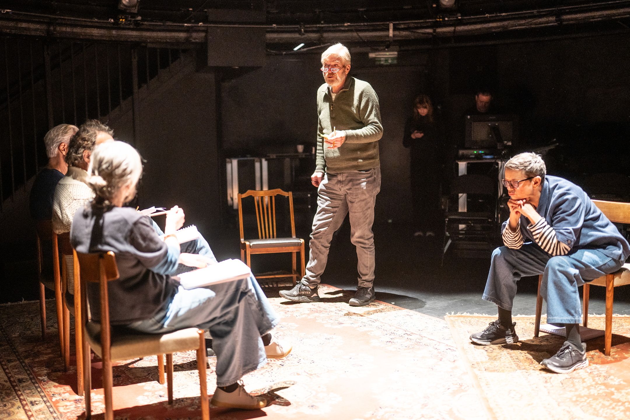 Fem personer som jobber med et manus på en scene