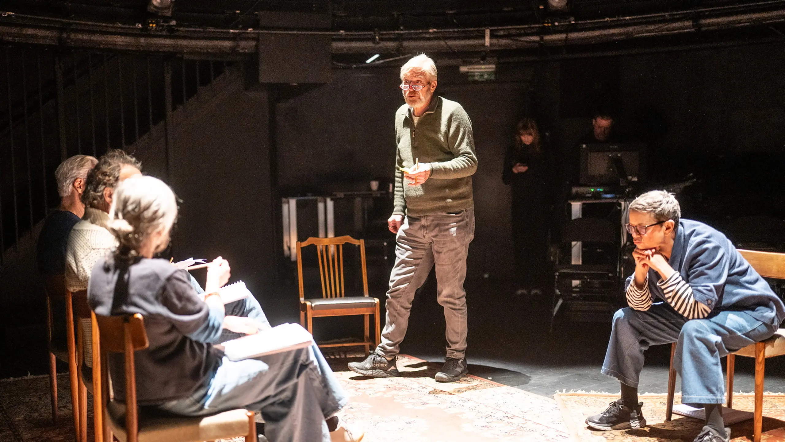 Fem personer som jobber med et manus på en scene