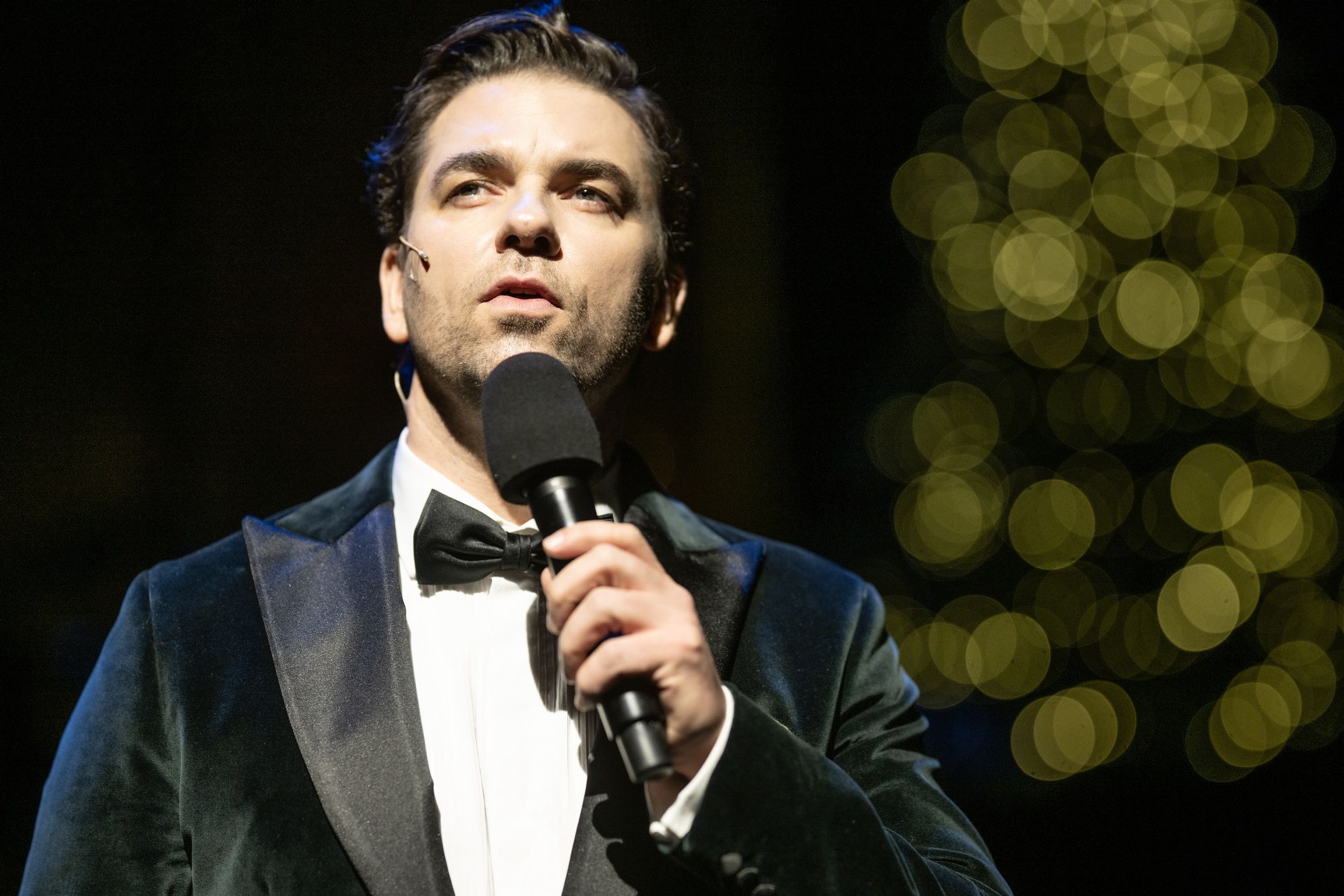 Smokingkledd mann foran julelys