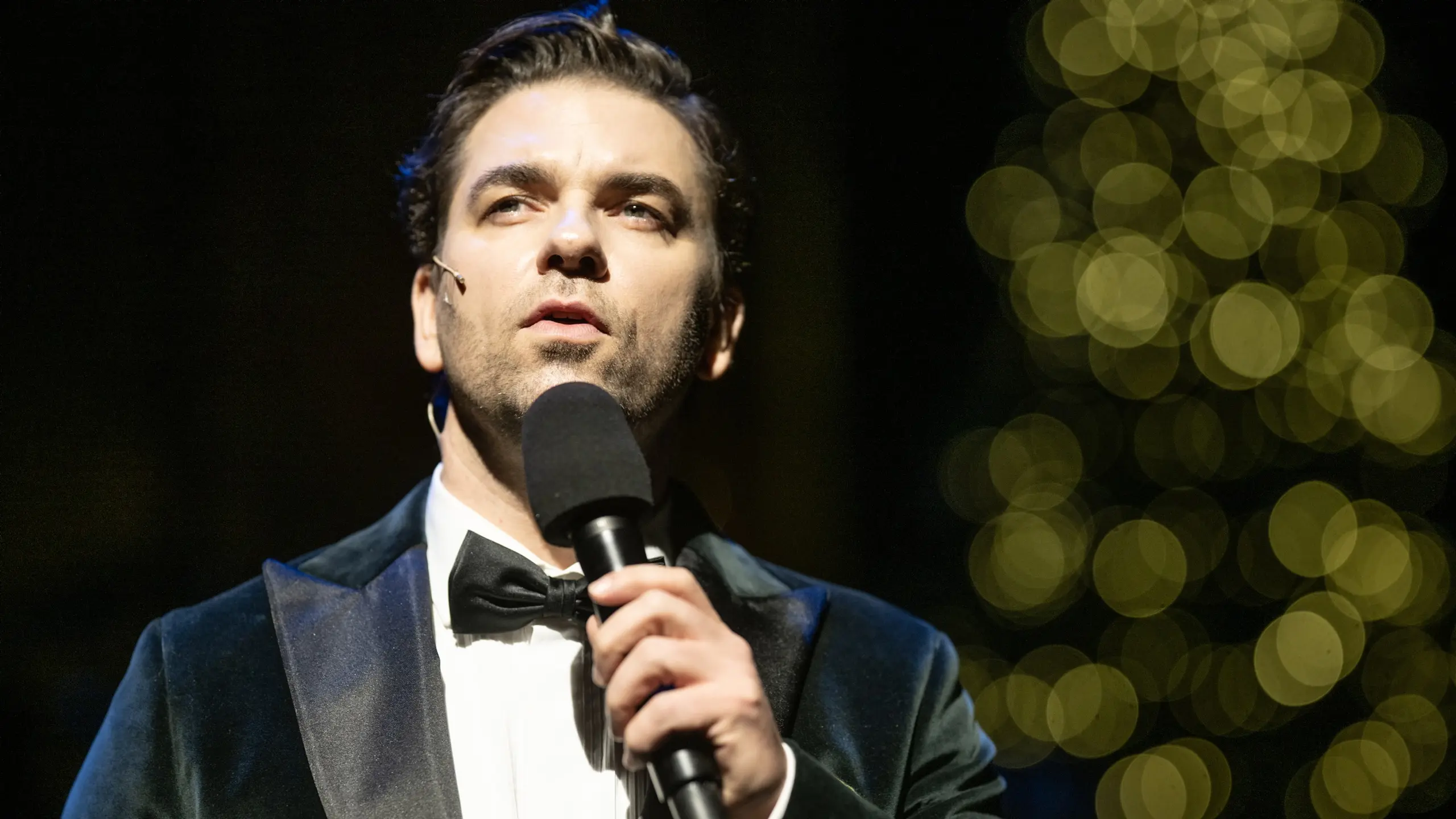 Smokingkledd mann foran julelys