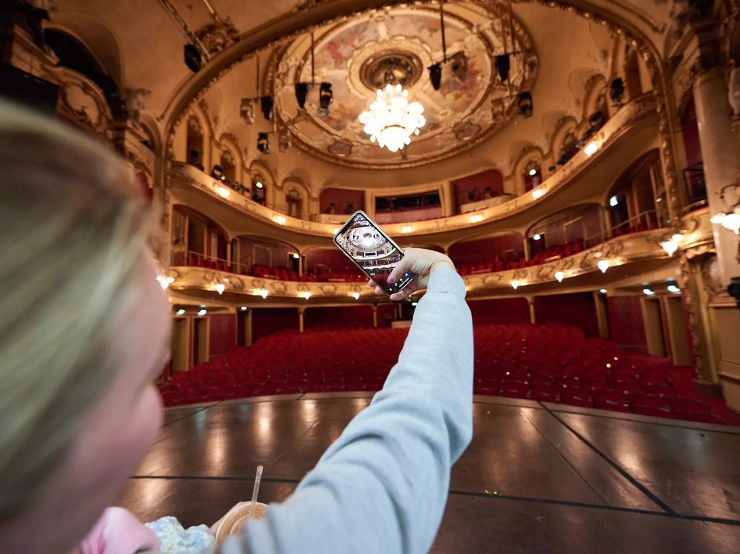 Arm som holder ut mobil for å ta bilde av Hovedscenen