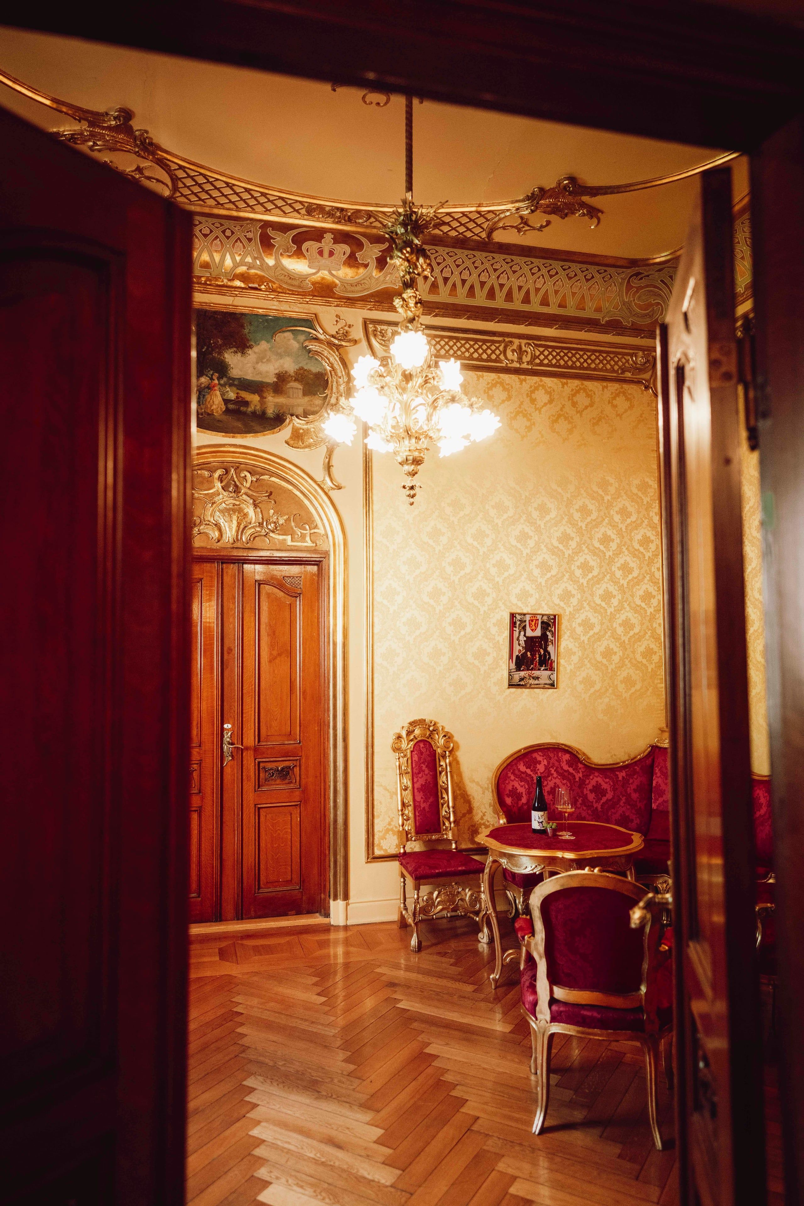 Interiørbilde fra Kongelosjen på Nationaltheatret med lysekrone, forgylte detaljer, historiske møbler og sittegruppe.