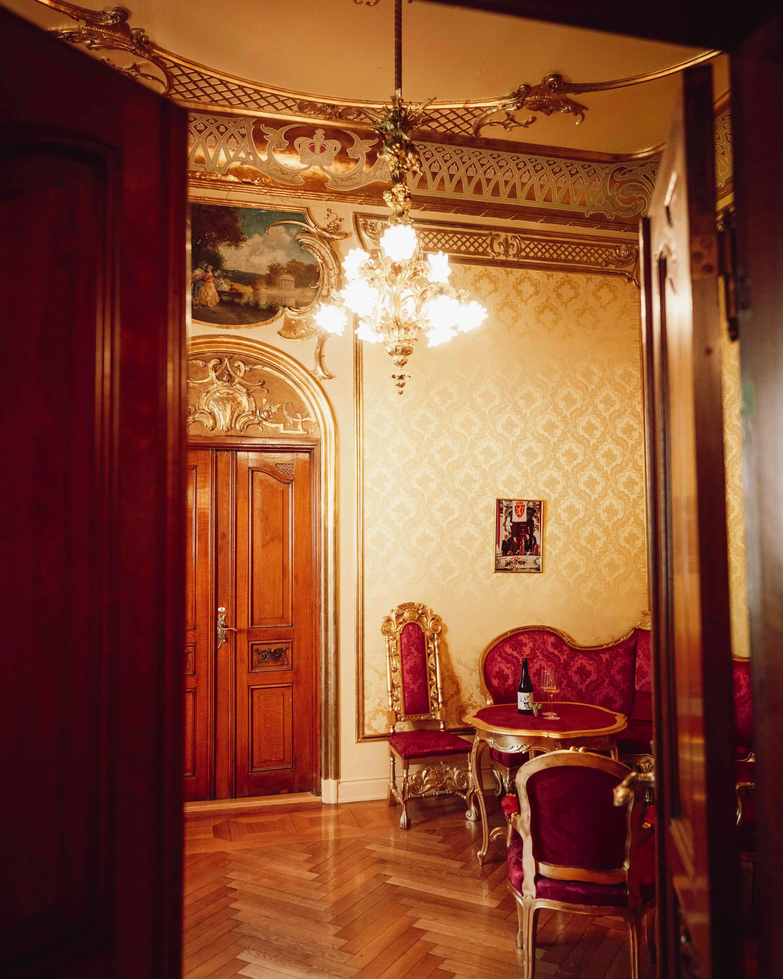 Interiørbilde fra Kongelosjen på Nationaltheatret med lysekrone, forgylte detaljer, historiske møbler og sittegruppe.