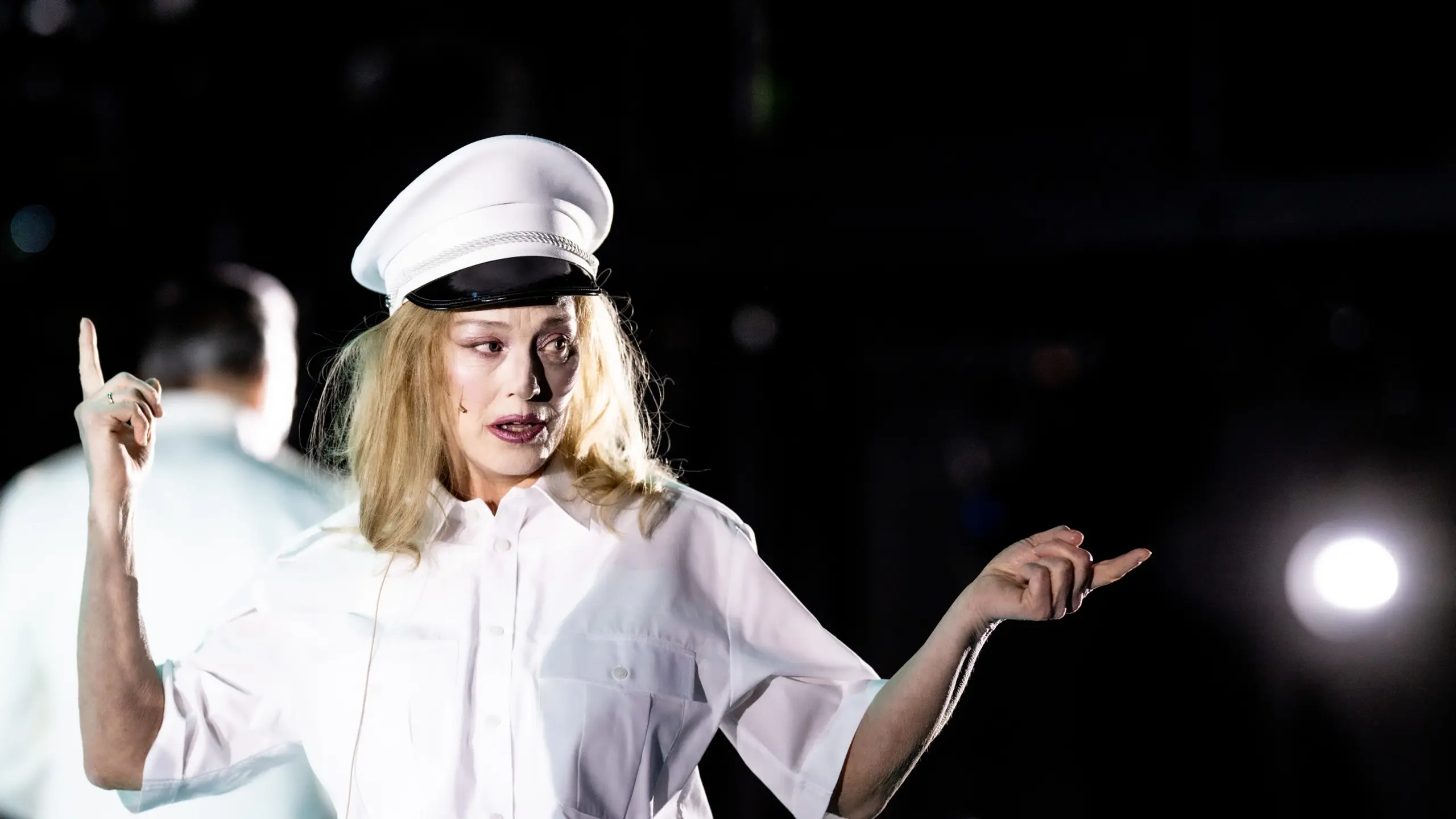 Kvinne i lys uniform som gestikulerer