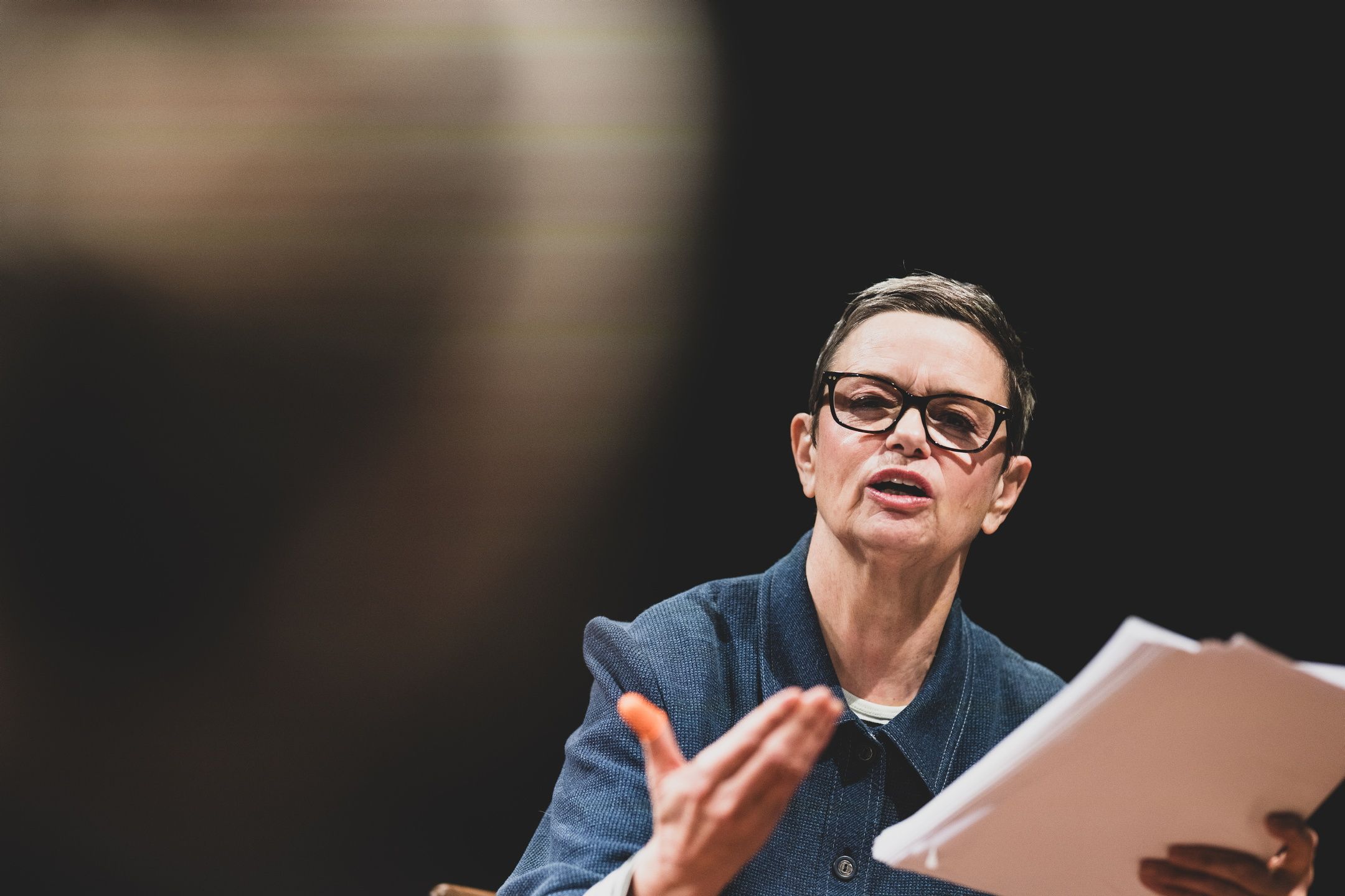 Kvinne med manus gestikulerer mot en annen person