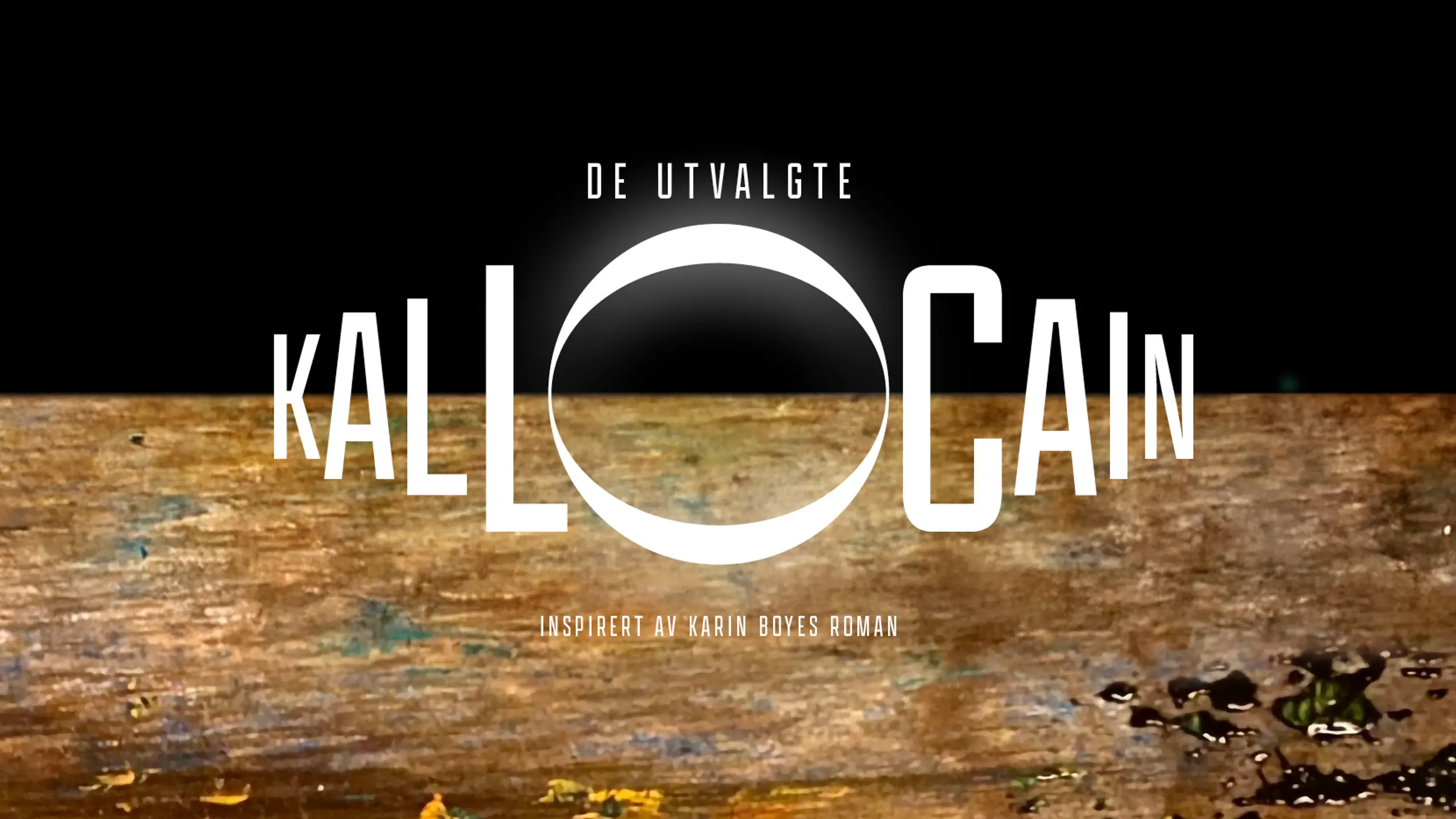 Noe som kan minne om en brun jordskorpe med dråper på mot svart himmel, med tekst De Utvalgte Kallocain inspirert av Karin Boyes roman