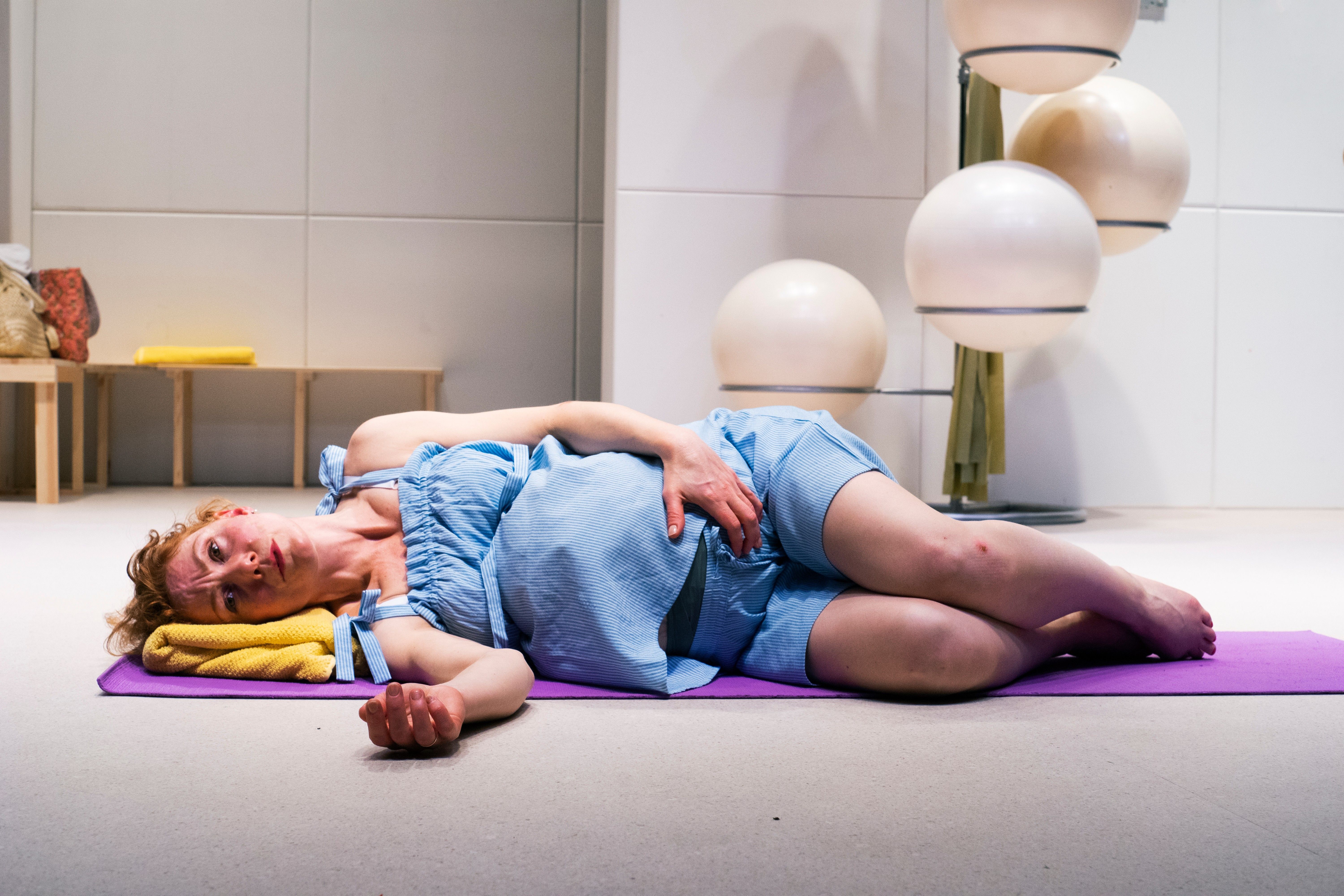 Fødende kvinne som ligger på siden i et yogastudio