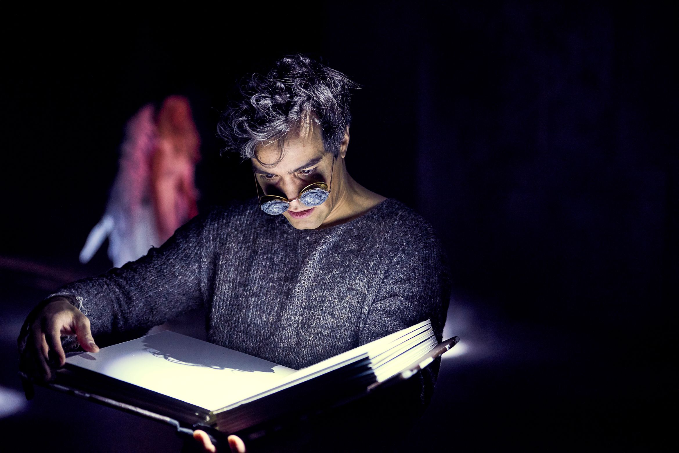 Hermann Sabado som leser i en stor bok i Engler i Amerika