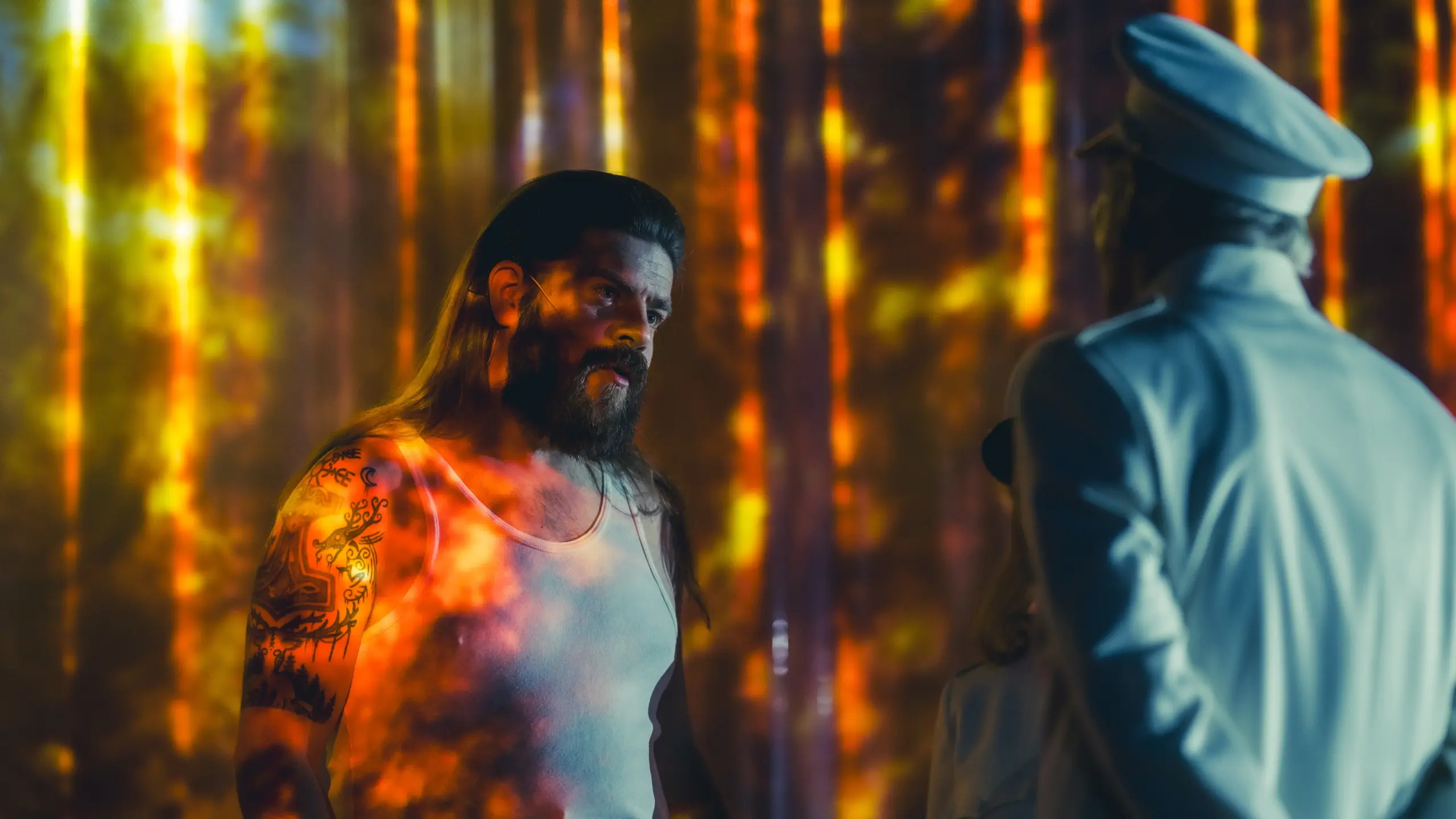 To menn i lys på scene. Den ene i hvit singlet, den andre med uniform