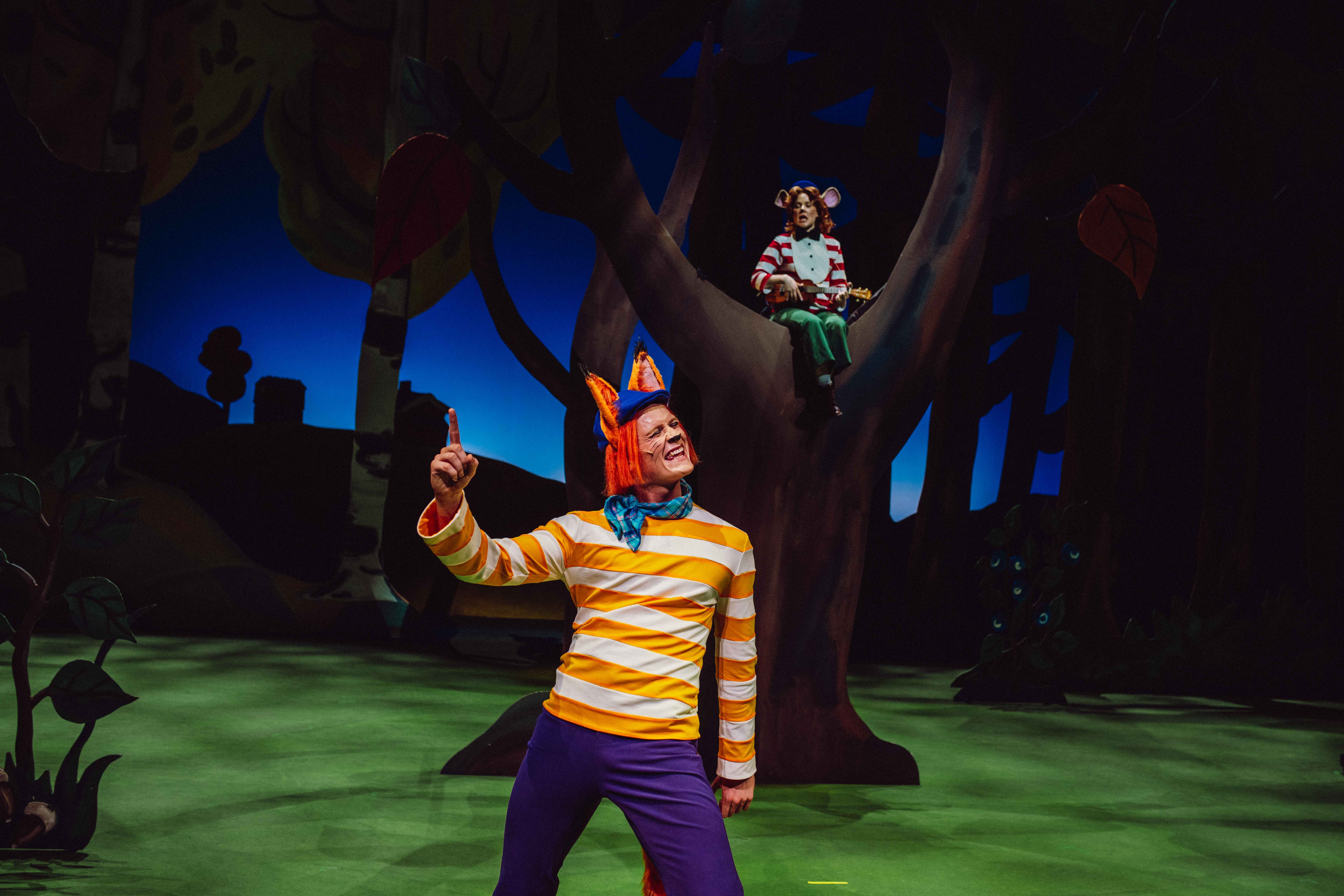 En rev i stripete genser peker dramatisk, mens en mus med ukulele sitter i et tre i bakgrunnen.