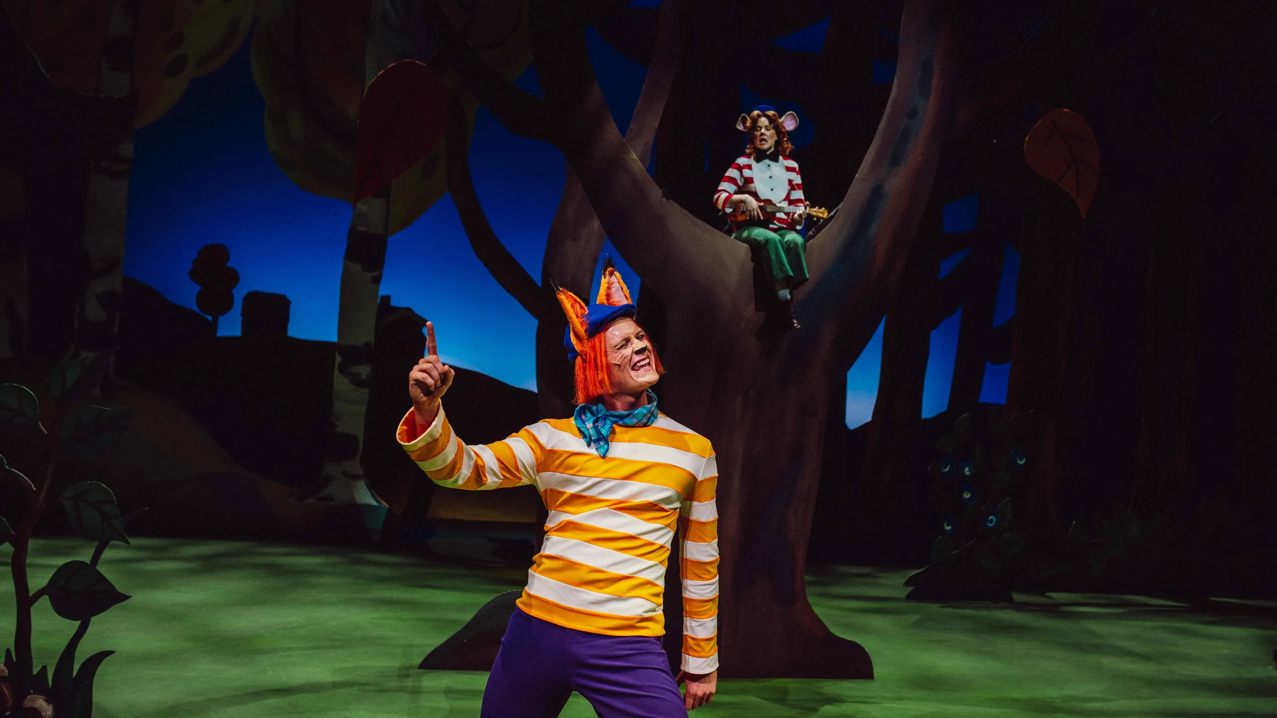 En rev i stripete genser peker dramatisk, mens en mus med ukulele sitter i et tre i bakgrunnen.