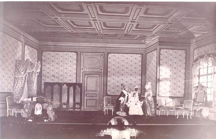 Gammelt bilde av scene som ser ut som en stue