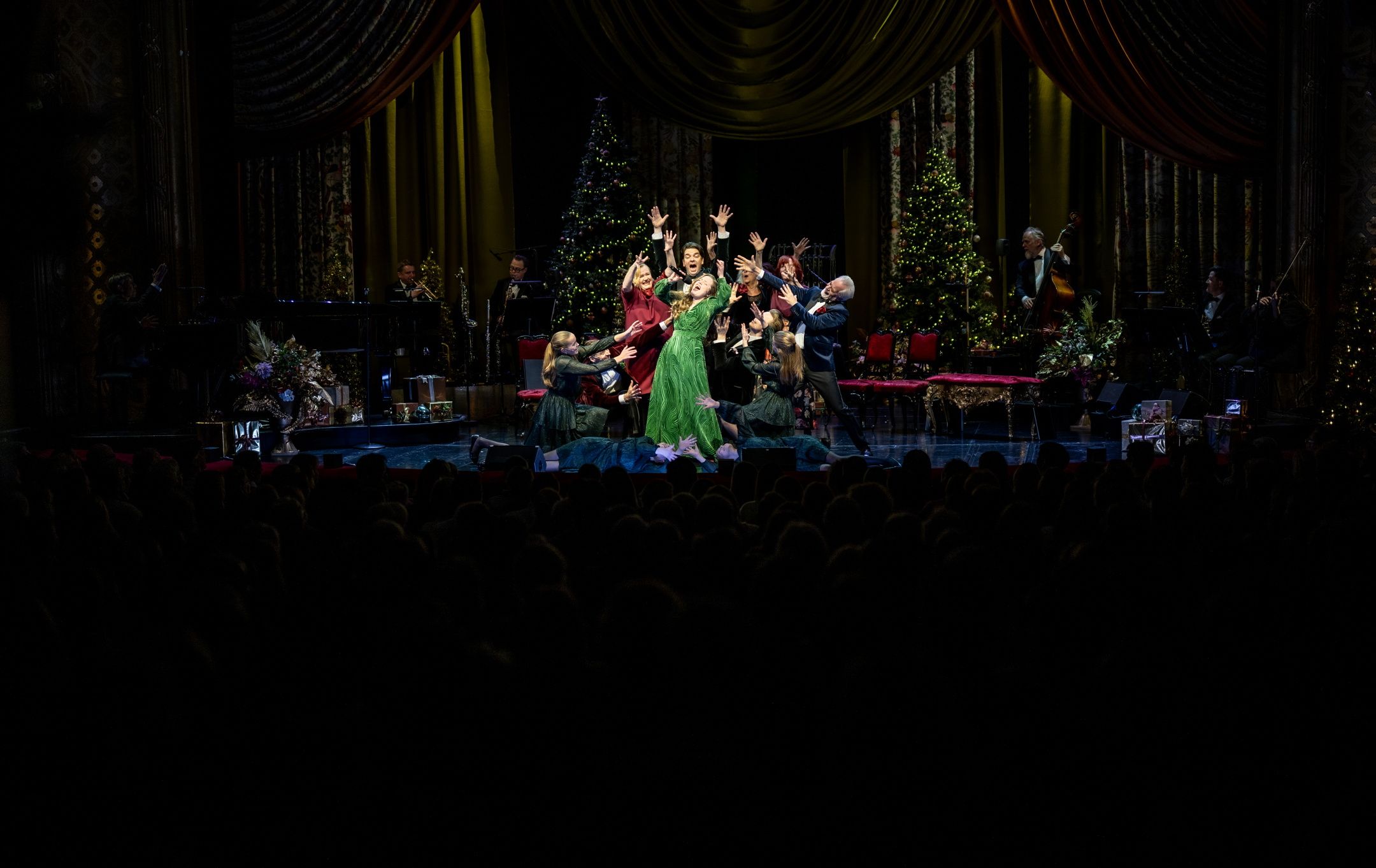 Folk som synger i en klynge på scenen