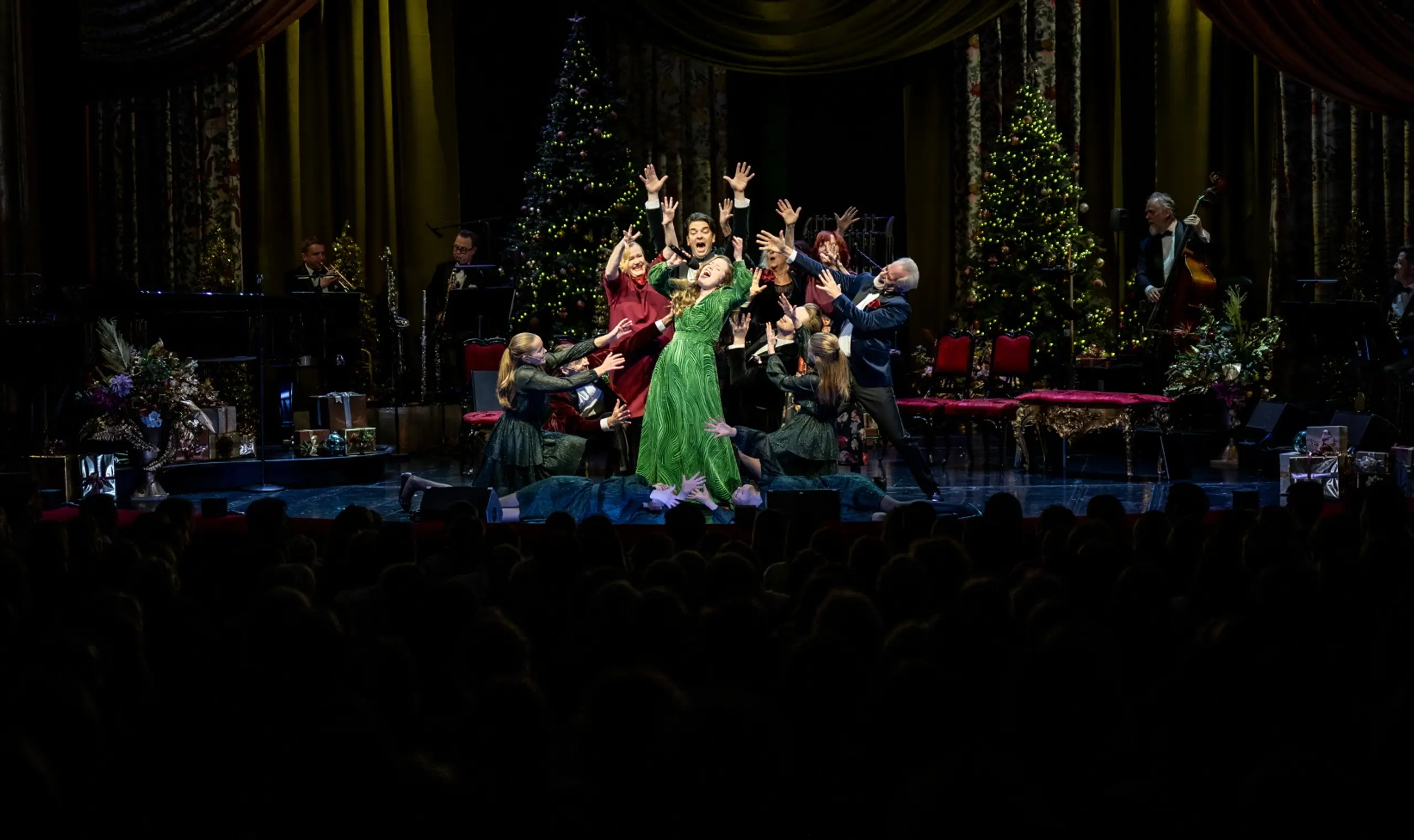 Folk som synger i en klynge på scenen