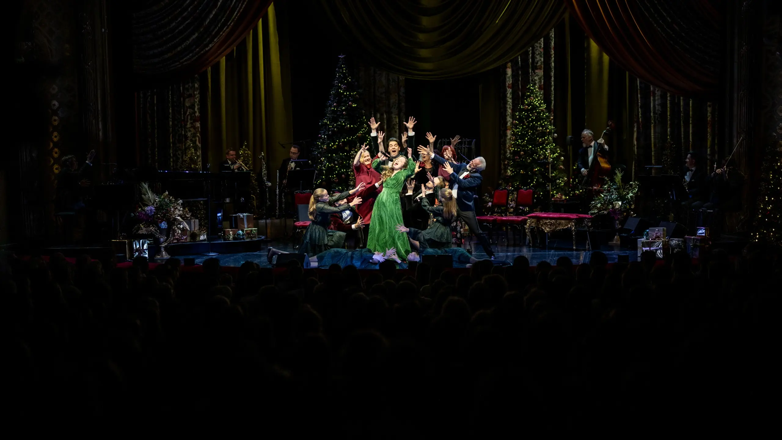 Folk som synger i en klynge på scenen