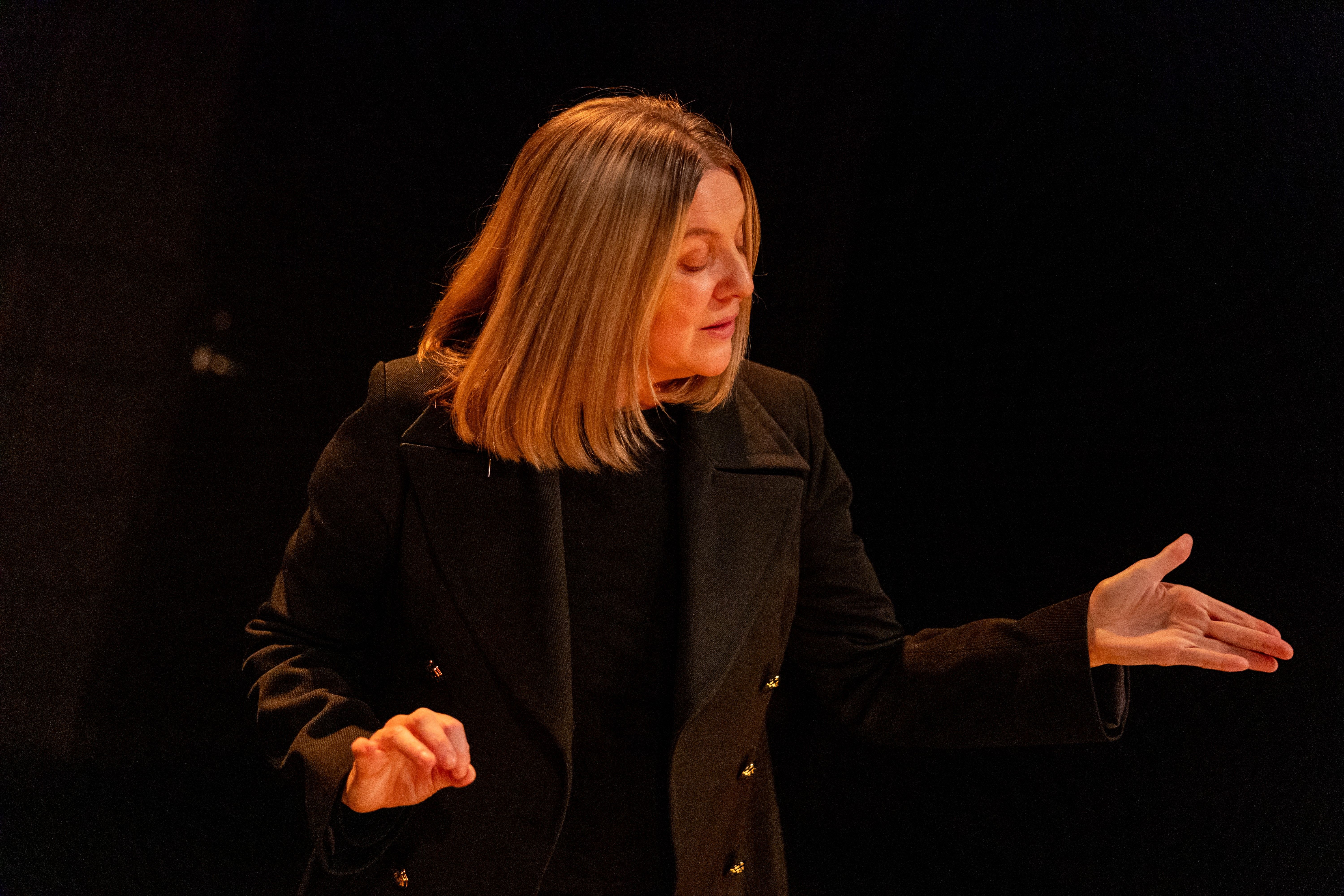 Kvinne som gestikulerer i gult lys