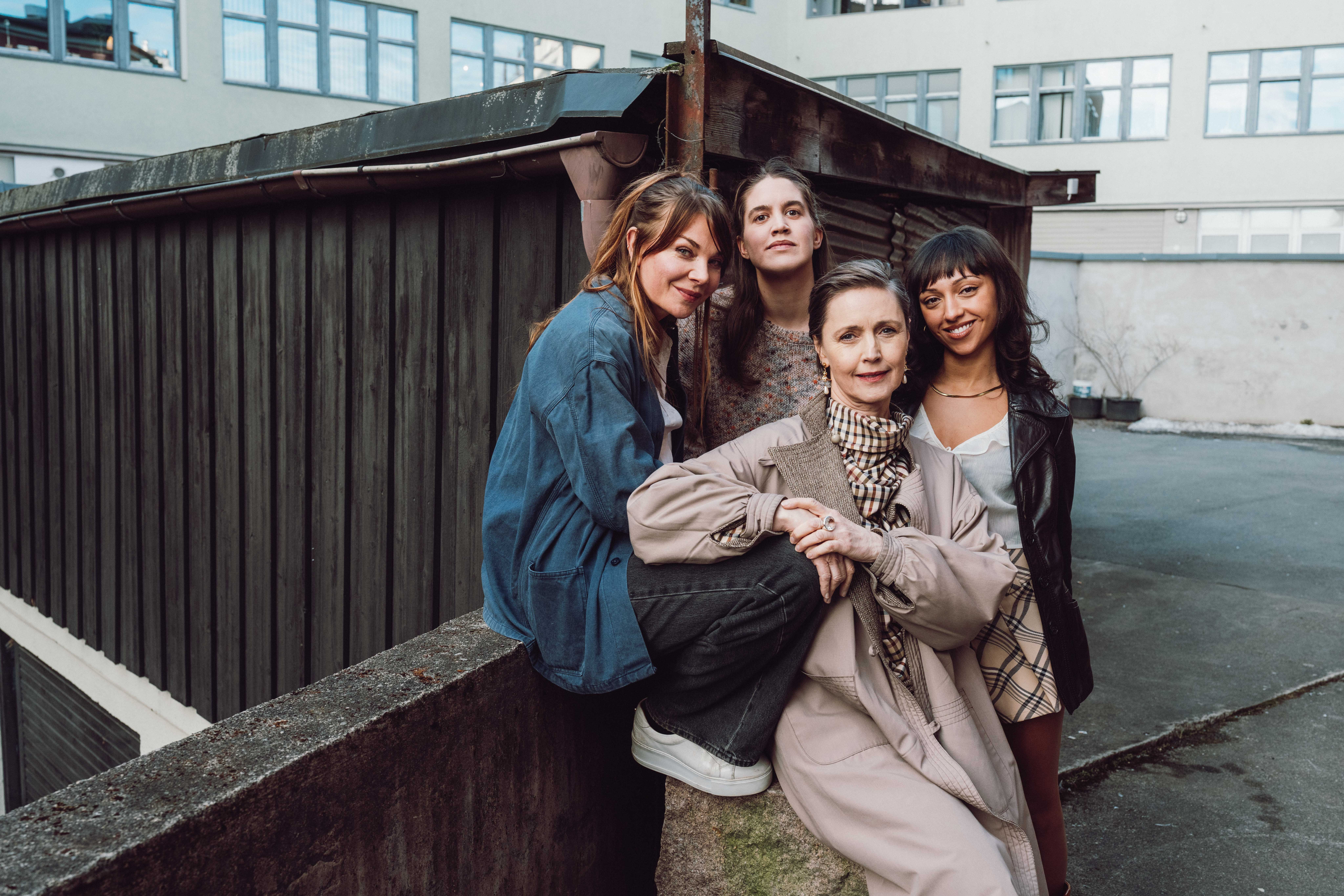 Gruppebilde av fire kvinner foran en bygning