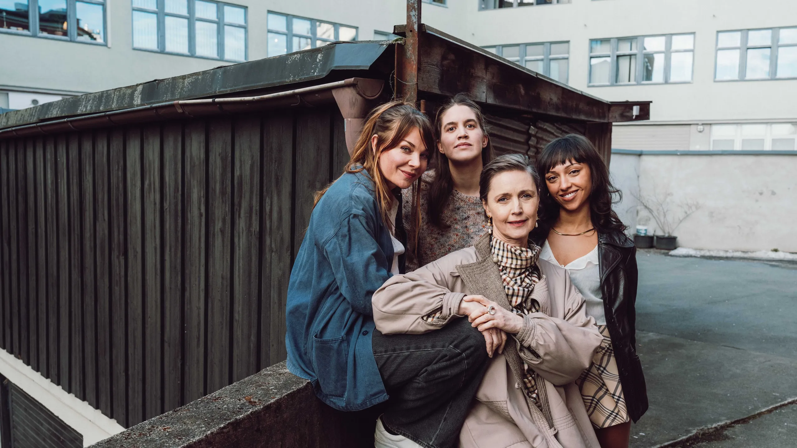 Gruppebilde av fire kvinner foran en bygning