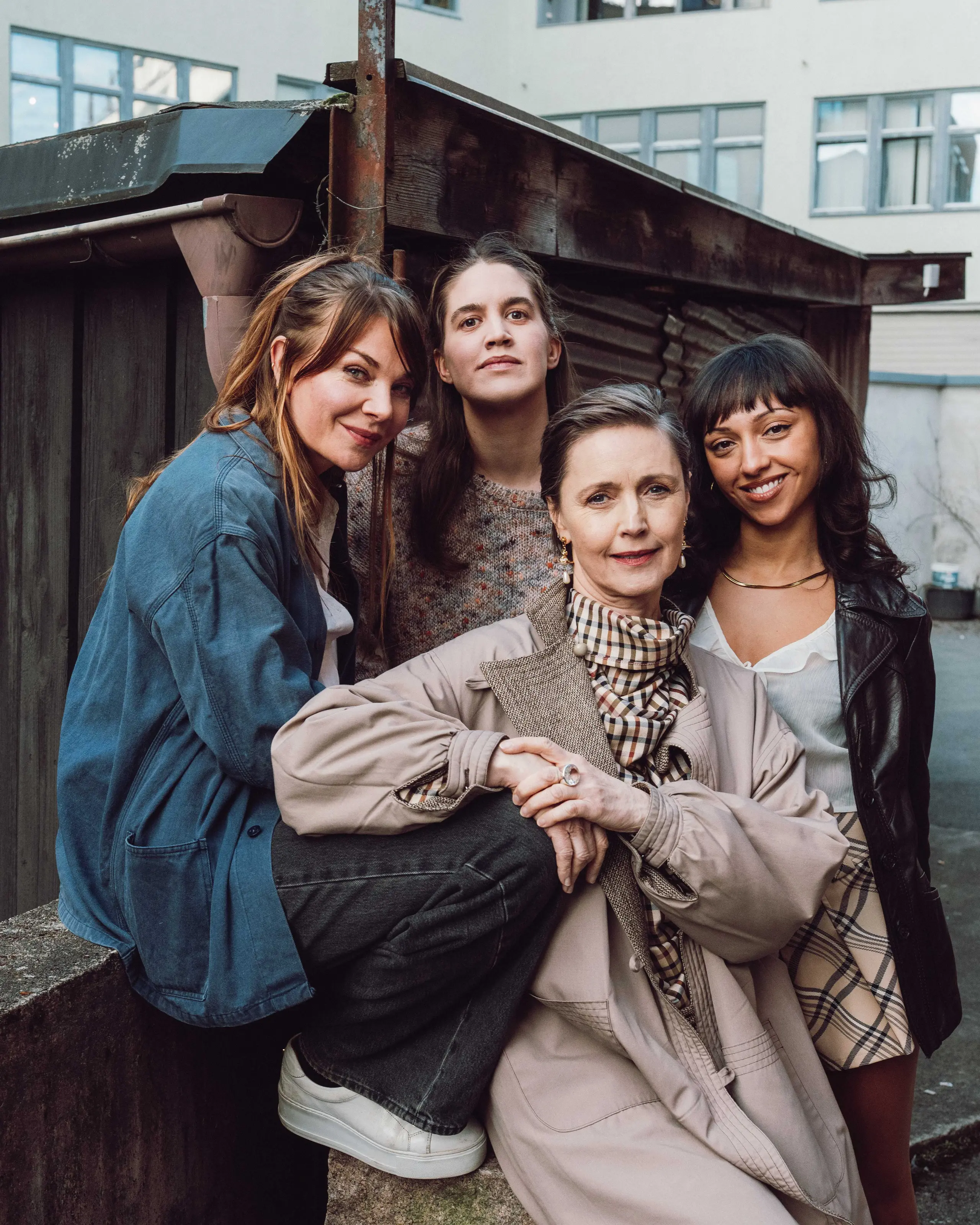 Gruppebilde av fire kvinner foran en bygning