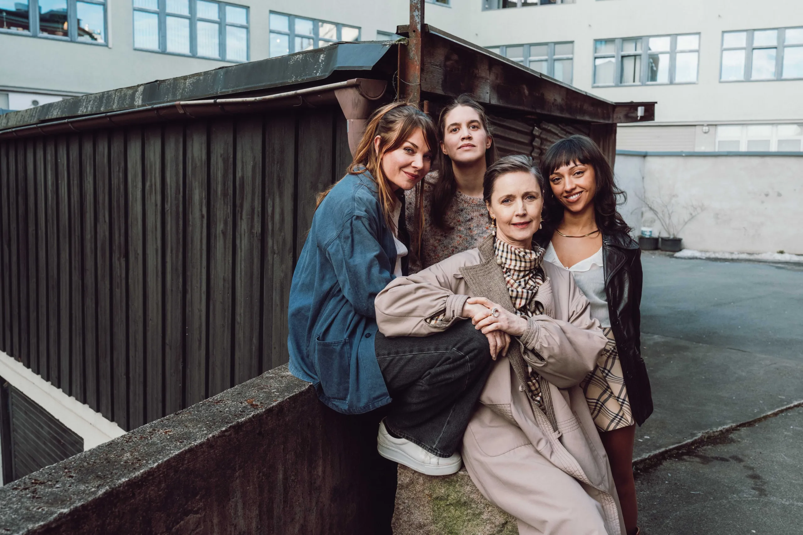 Gruppebilde av fire kvinner foran en bygning