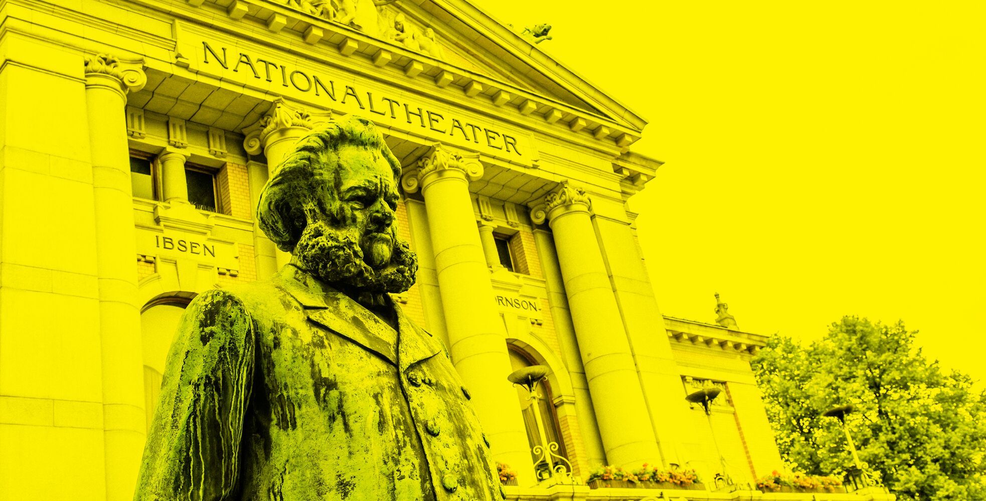 Ibsen-statuen foran Nationaltheatret, med gult filter på