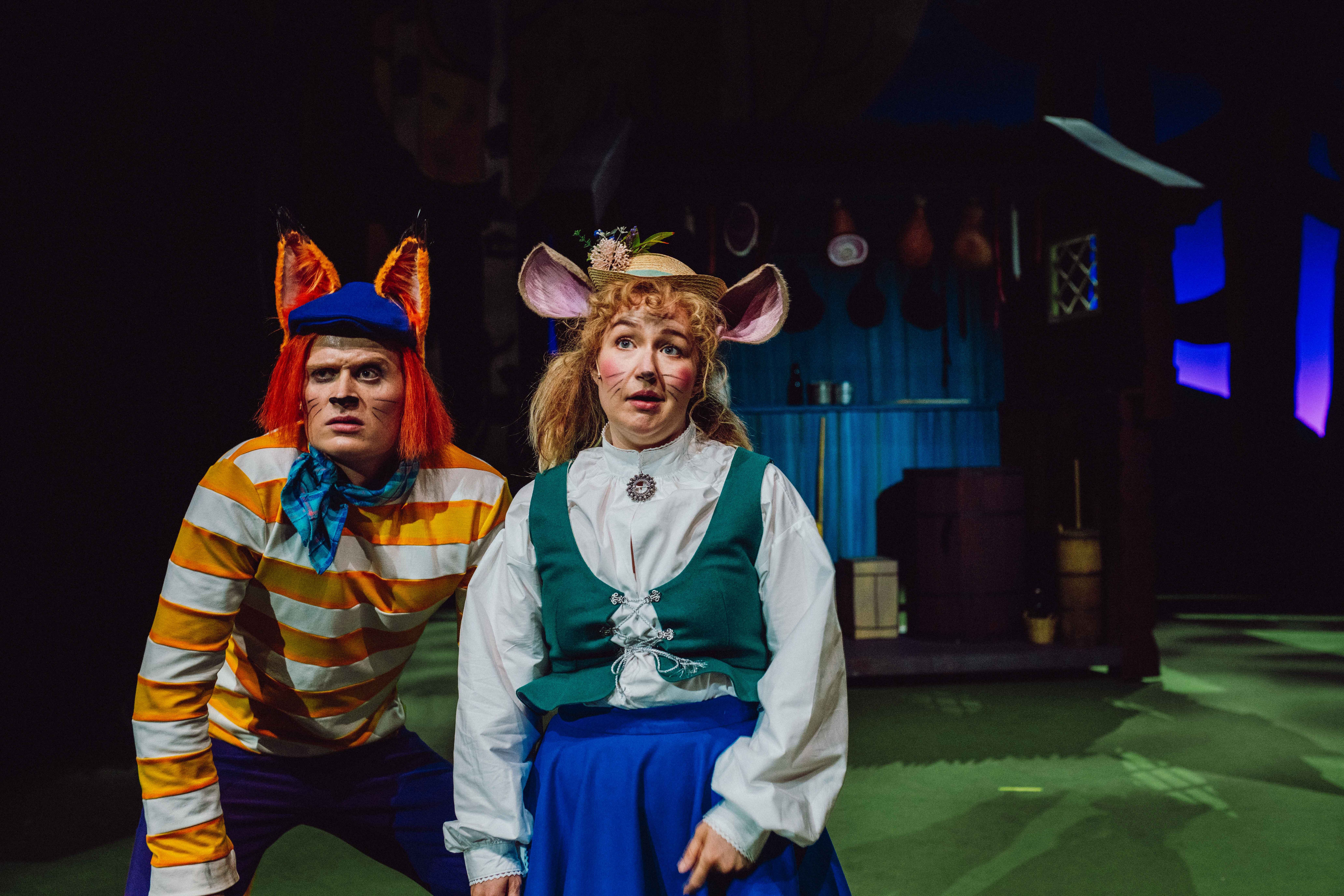 En rev og en mus ser alvorlige ut på scenen med skogshytte i bakgrunnen.