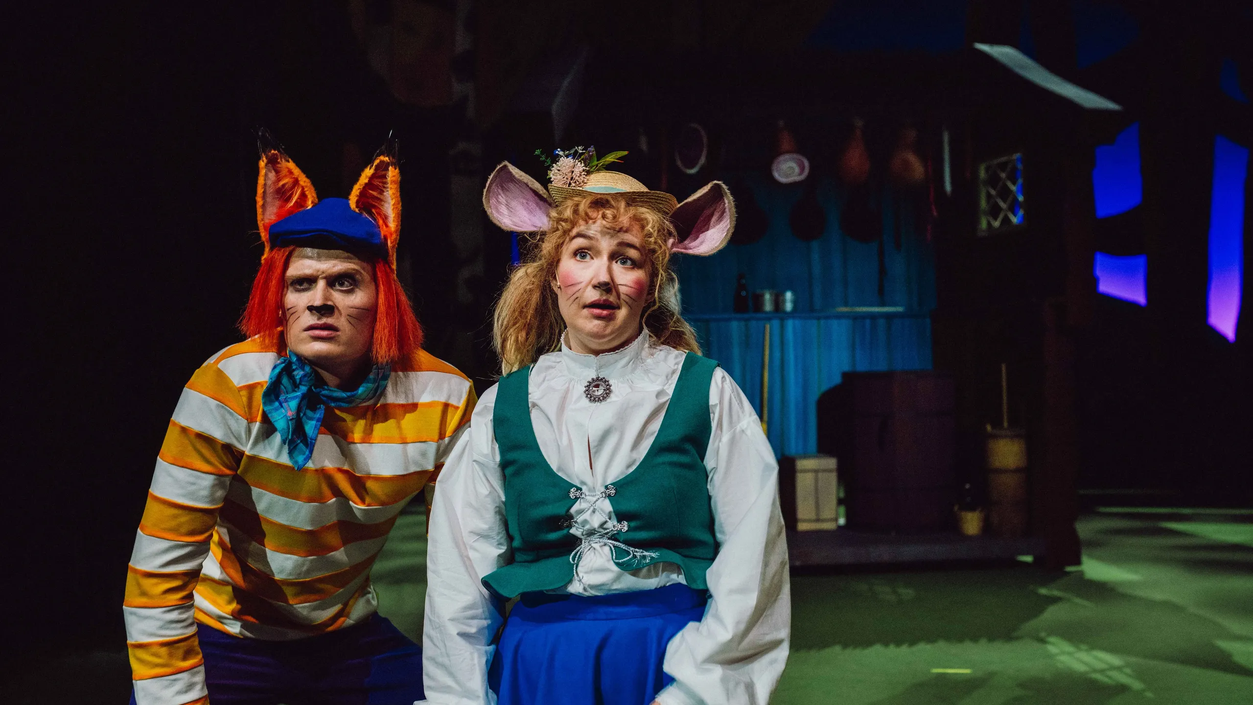 En rev og en mus ser alvorlige ut på scenen med skogshytte i bakgrunnen.