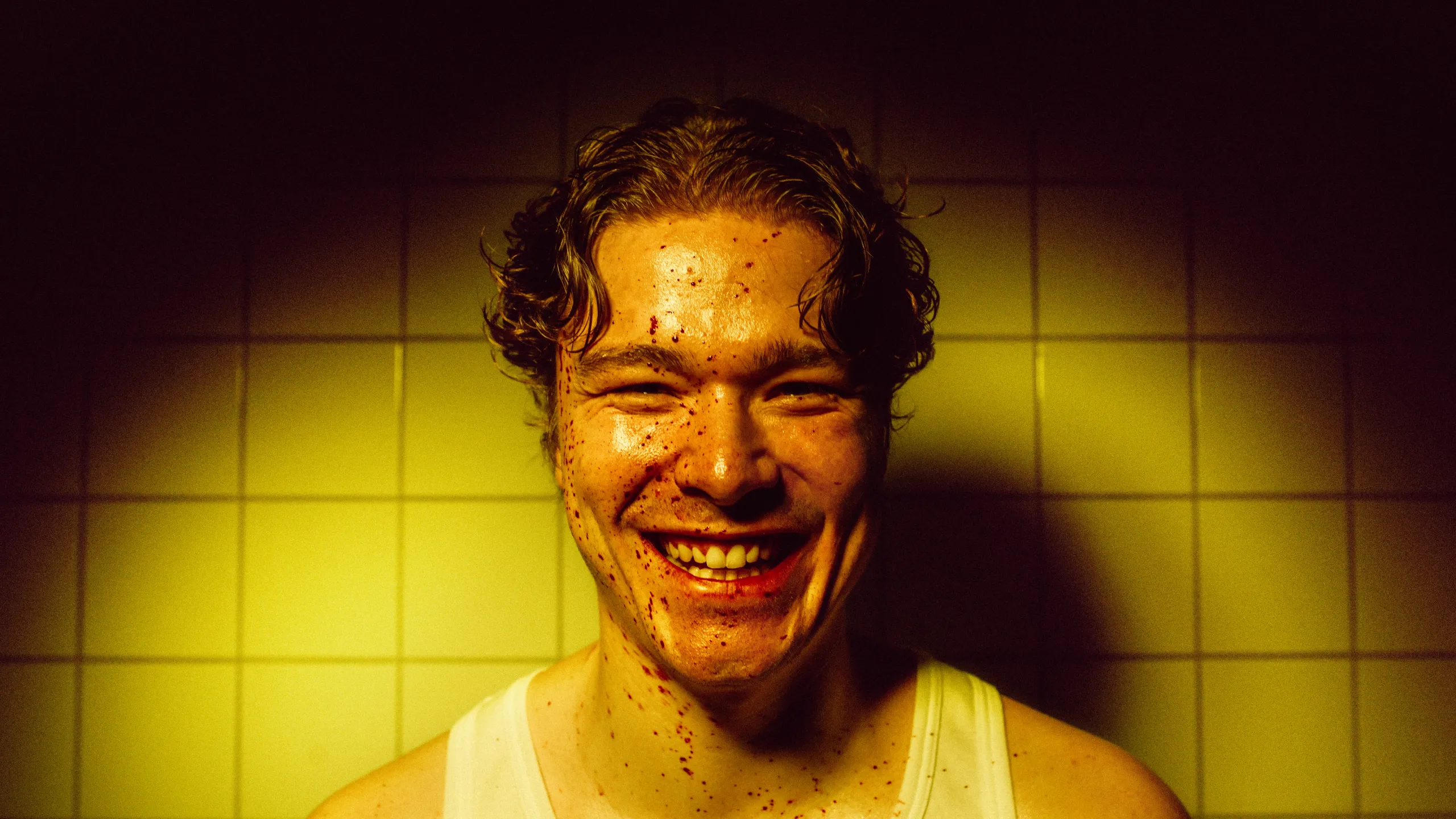 Portrett av mann med blod i fjeset mot gule fliser