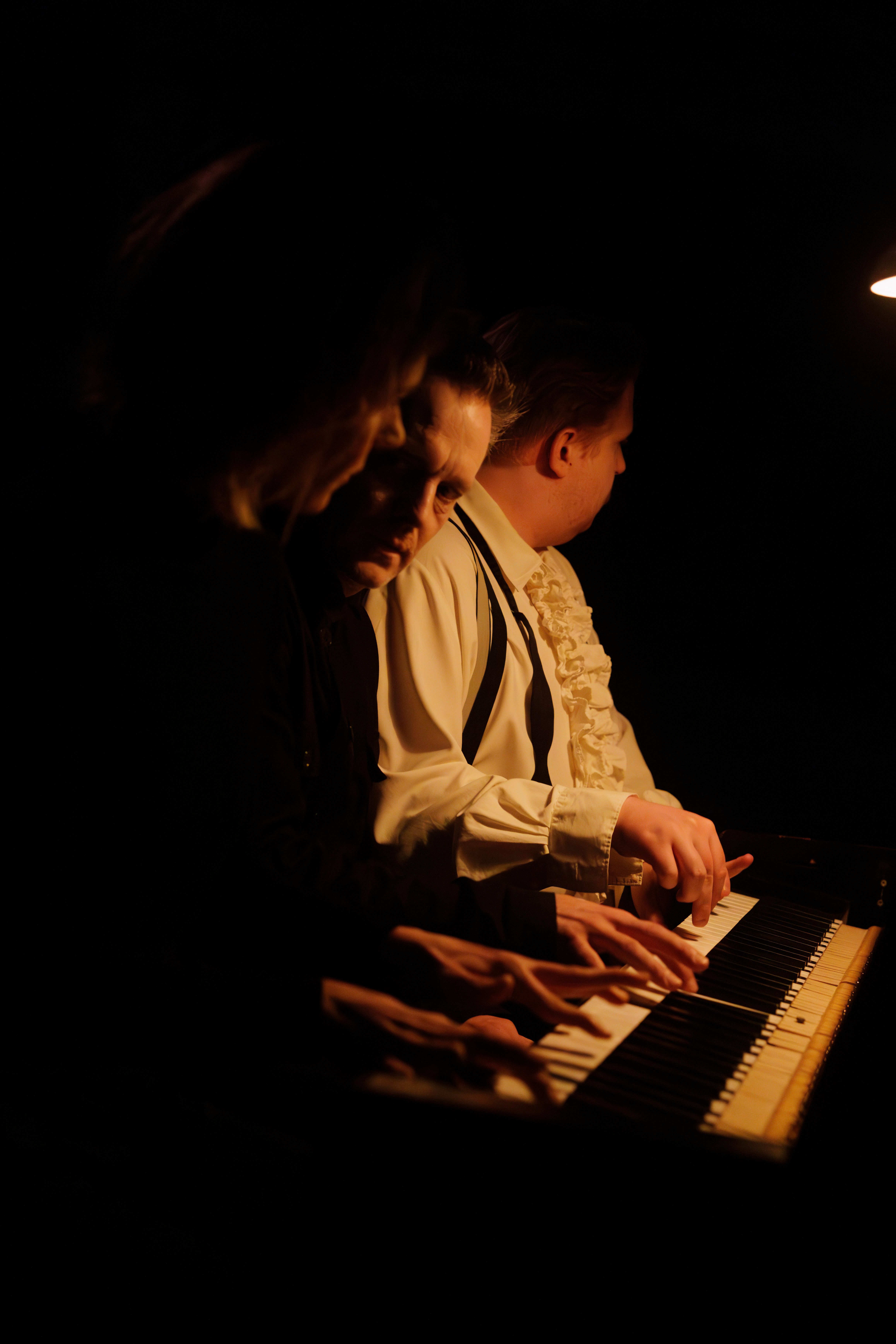 Tre personer ved piano