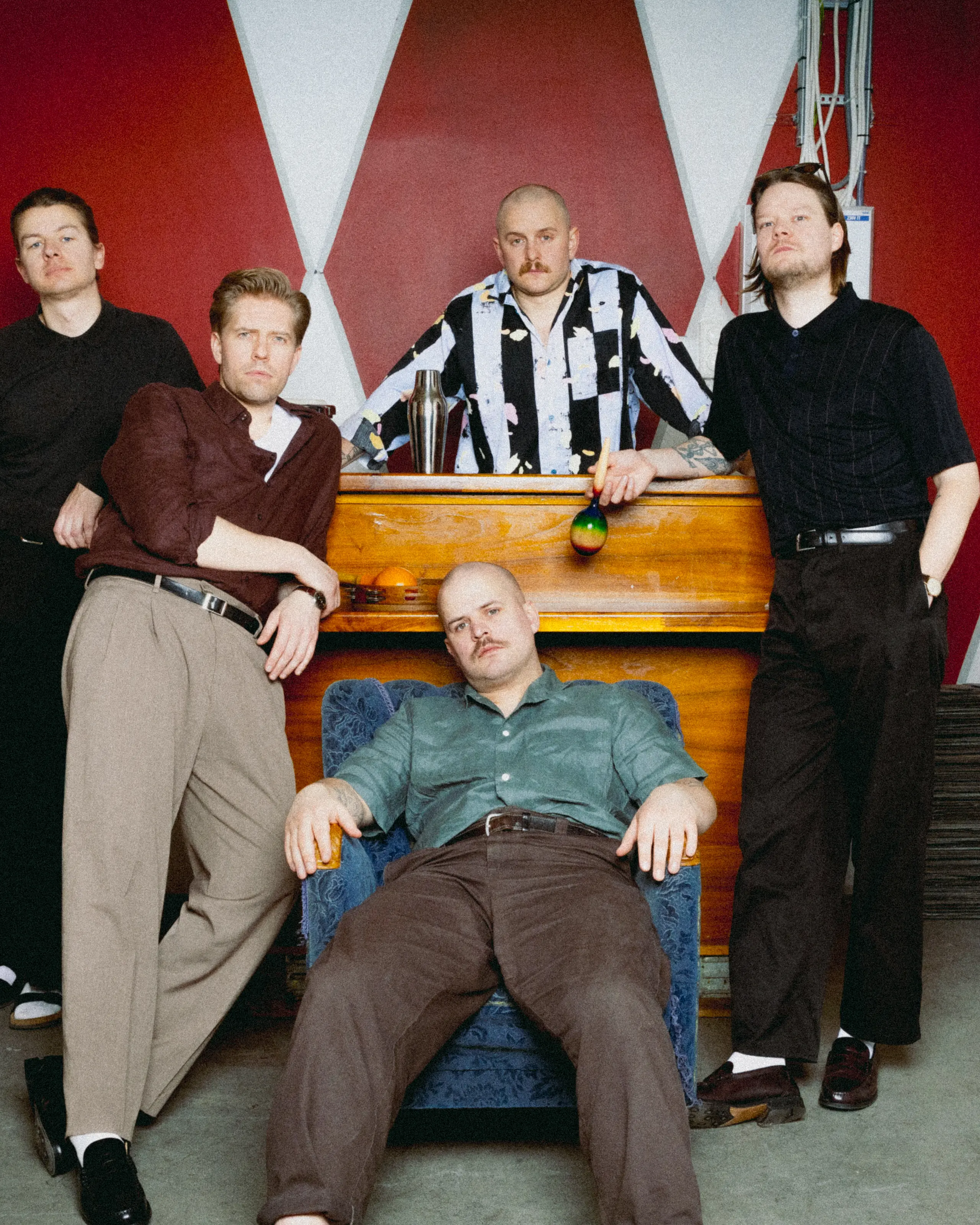 Fem unge menn står henslengt rundt et piano.