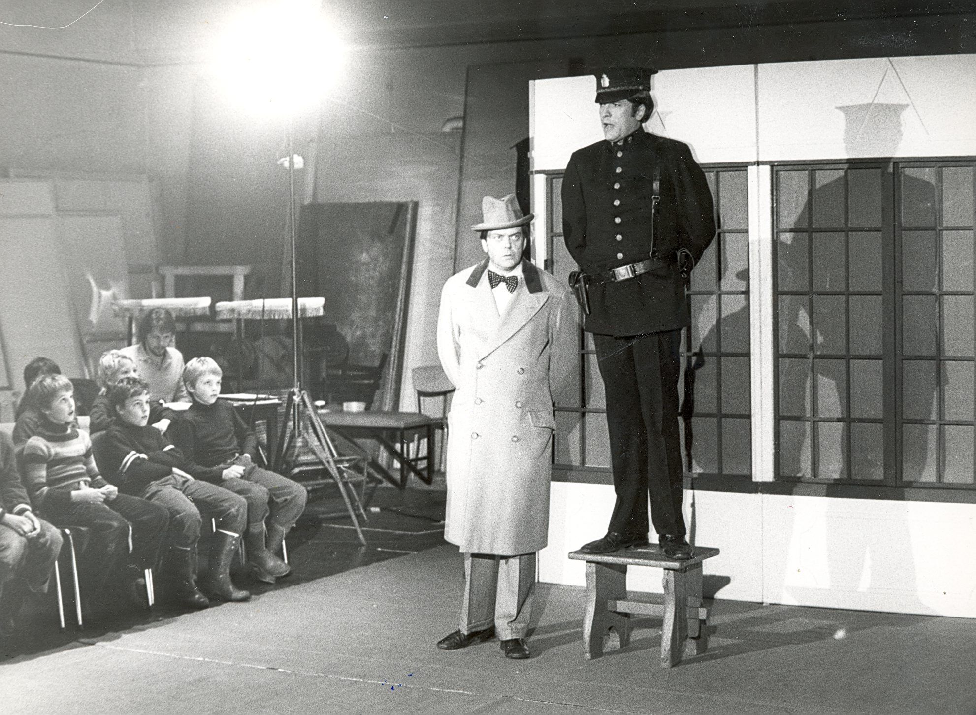 To menn på scenen foran et barnlig publikum