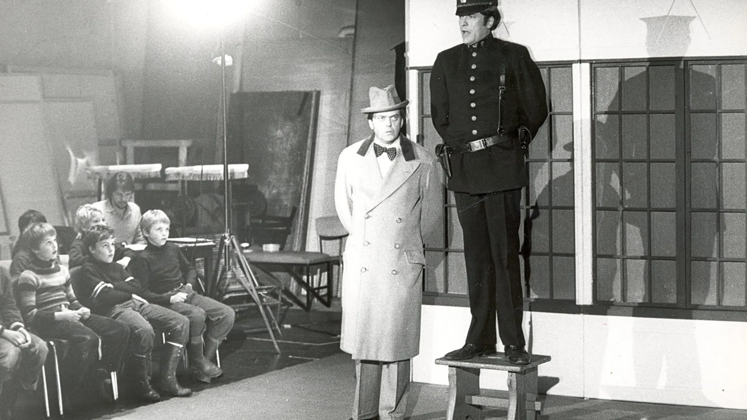 To menn på scenen foran et barnlig publikum